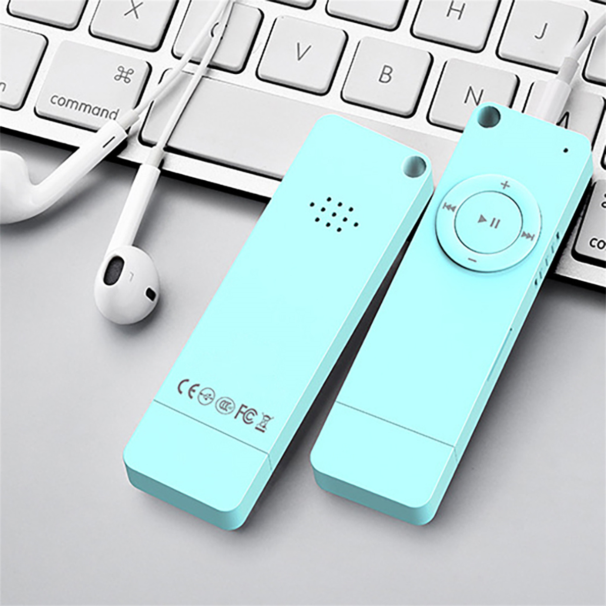 Zwei türkisfarbene MP3-Player mit Kopfhörern auf einer Tastatur.