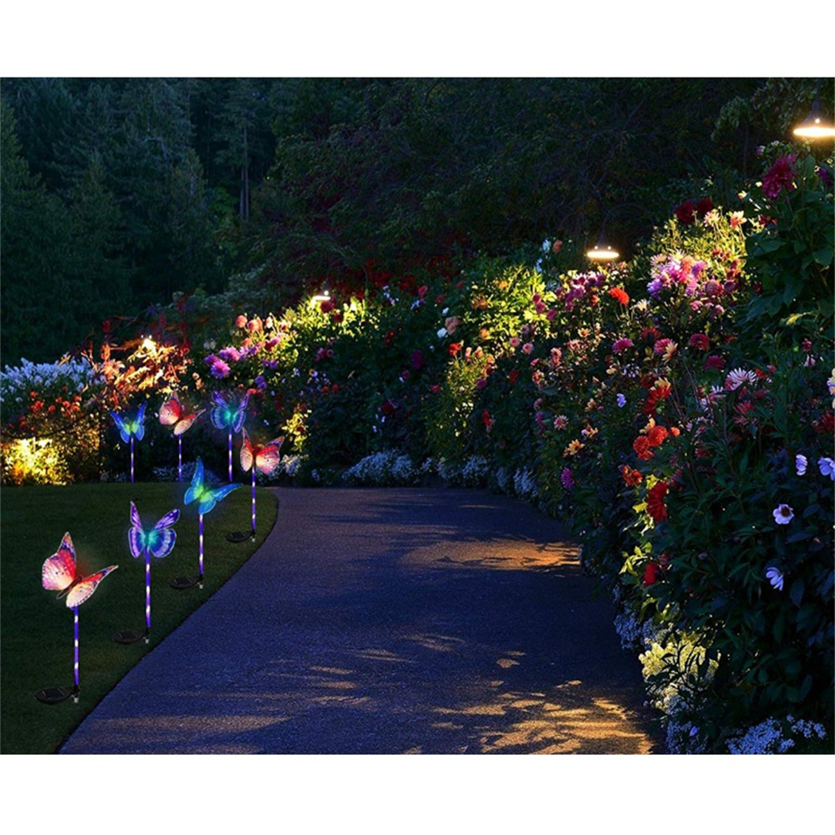 Gartenweg mit Schmetterlingslichtern auf beiden Seiten. Blumen und Büsche sind ebenfalls sichtbar. Dämmerung.