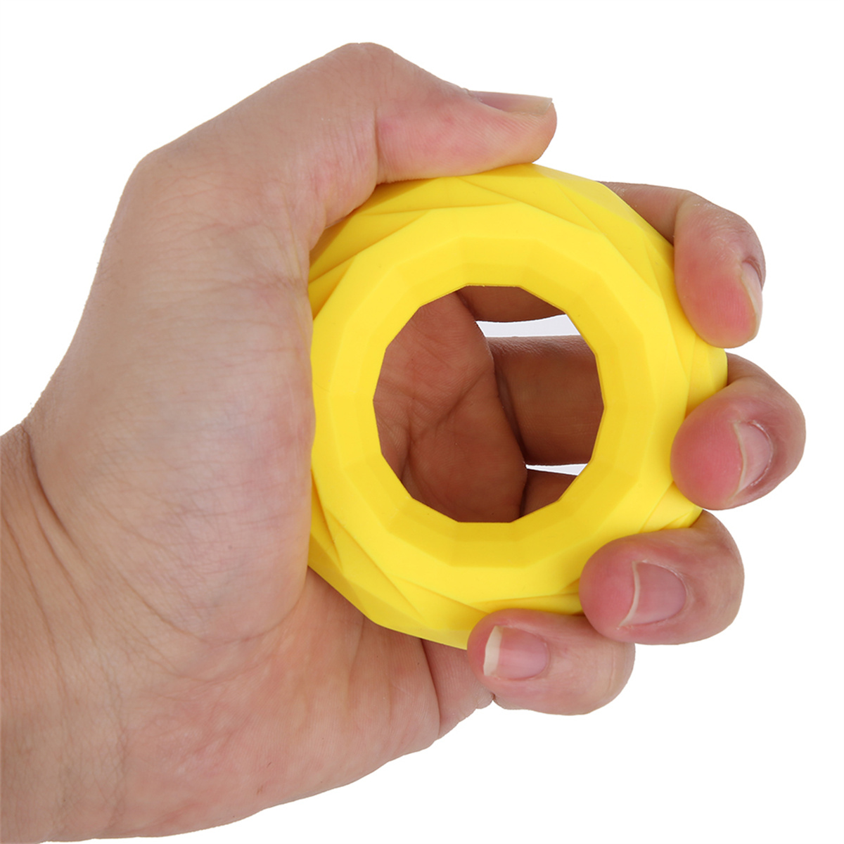 Eine Hand hält ein gelbes, geometrisches, ringförmiges Trainingsgerät.