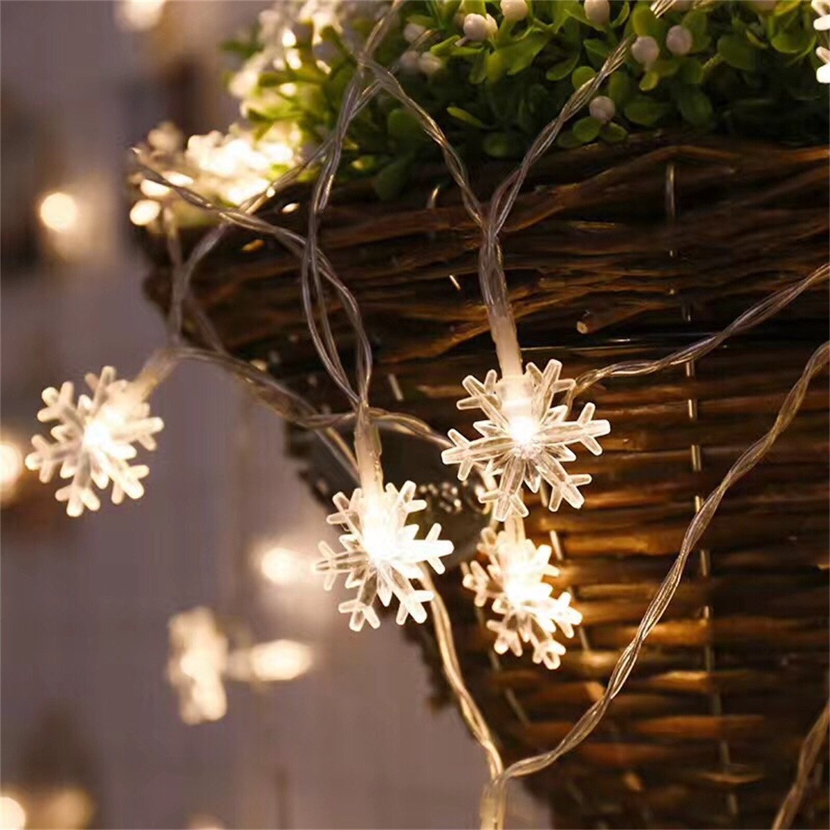 Eine Lichterkette mit schneeförmigen Lichtern, die vor einem geflochtenen Korb hängt.