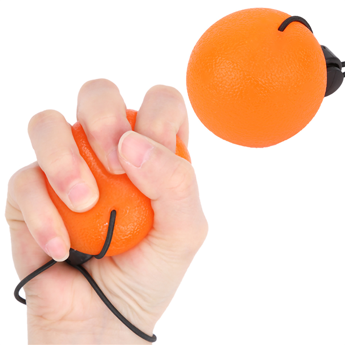 Eine Hand, die einen orangenen Stressball mit einem schwarzen Faden zusammendrückt, ein weiterer oranger Ball im Hintergrund.