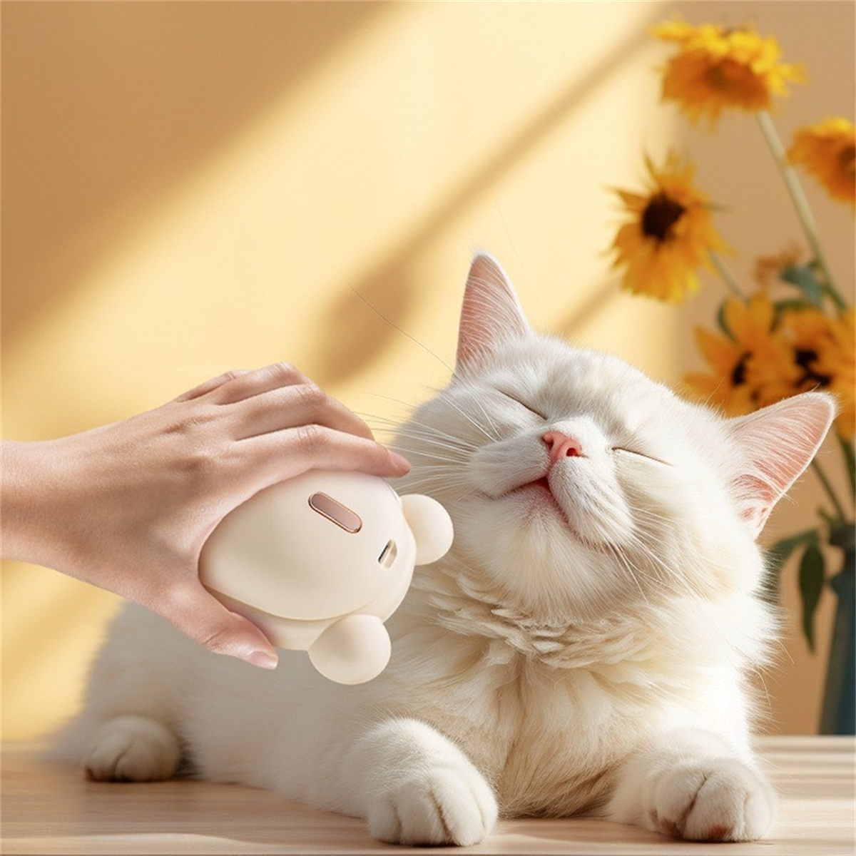 Eine weiße Katze, die mit einem cremefarbenen Katzenhaarentferner gepflegt wird.