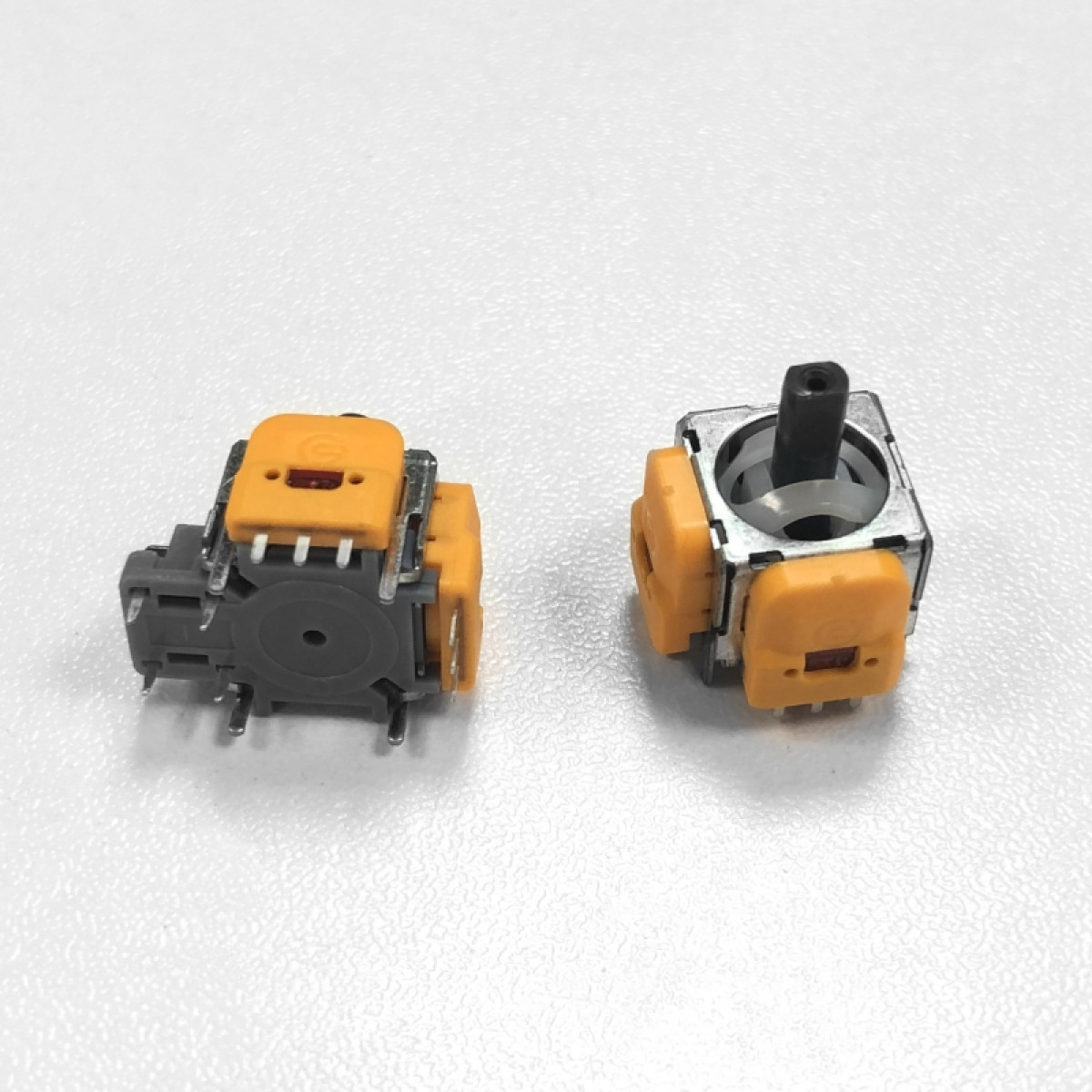 Zwei PS5-Joystick-Module. Orange und graue Module, schwarze Sticks.
