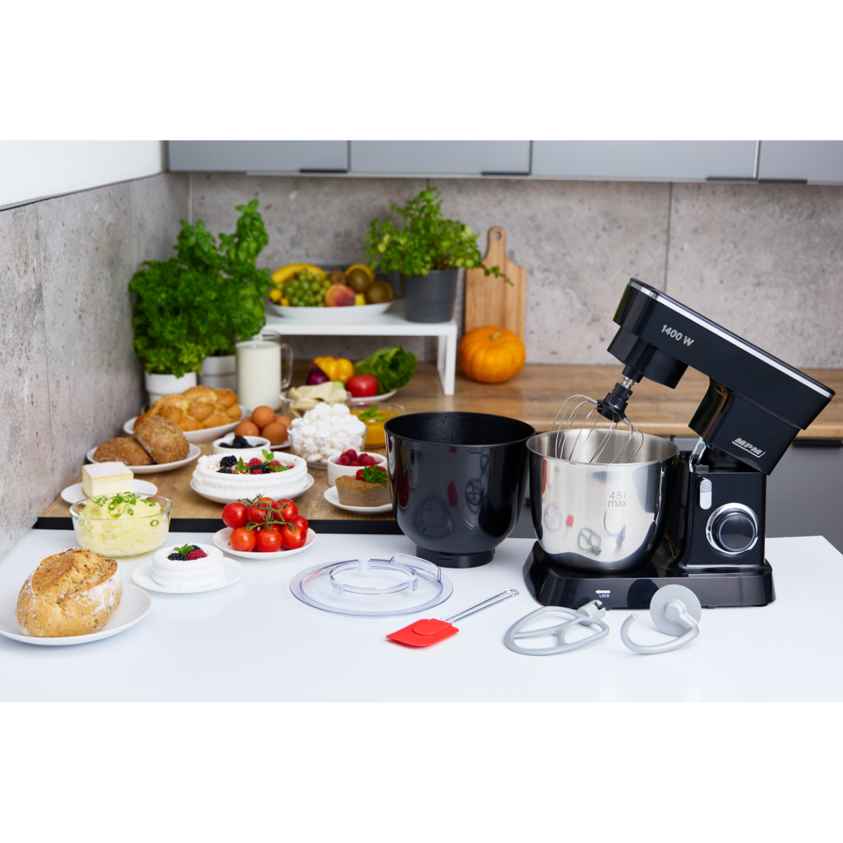 Una cucina con un robot da cucina nero, ingredienti e cibo. Un tavolo è in primo piano.
