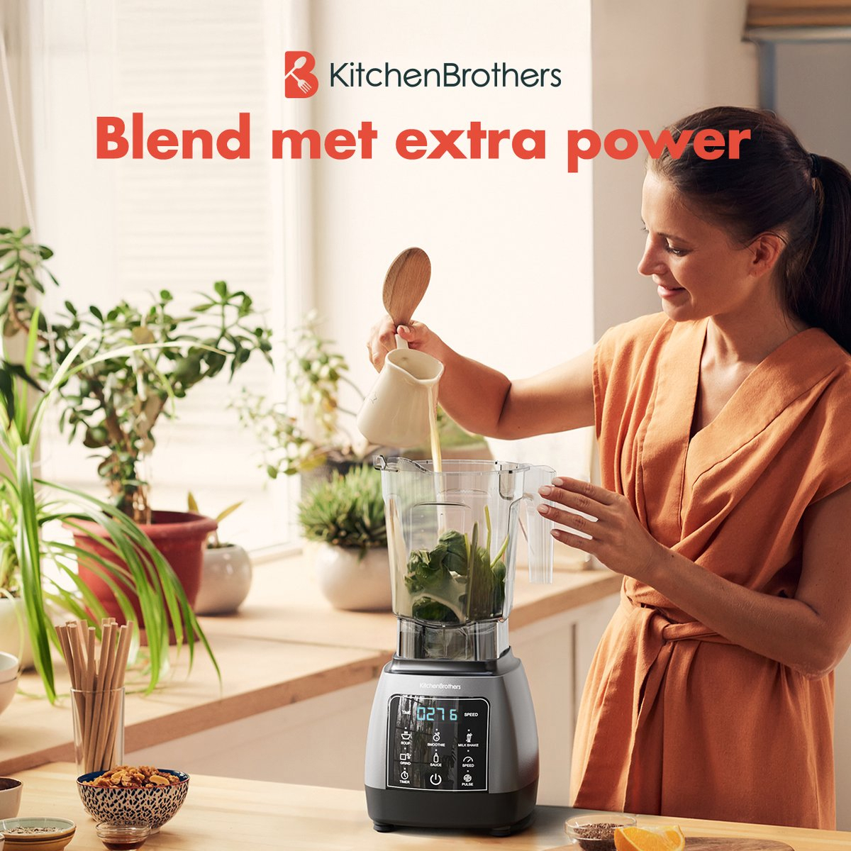 Een vrouw giet vloeistof uit een witte kan in een blender met ingrediënten op een aanrecht.