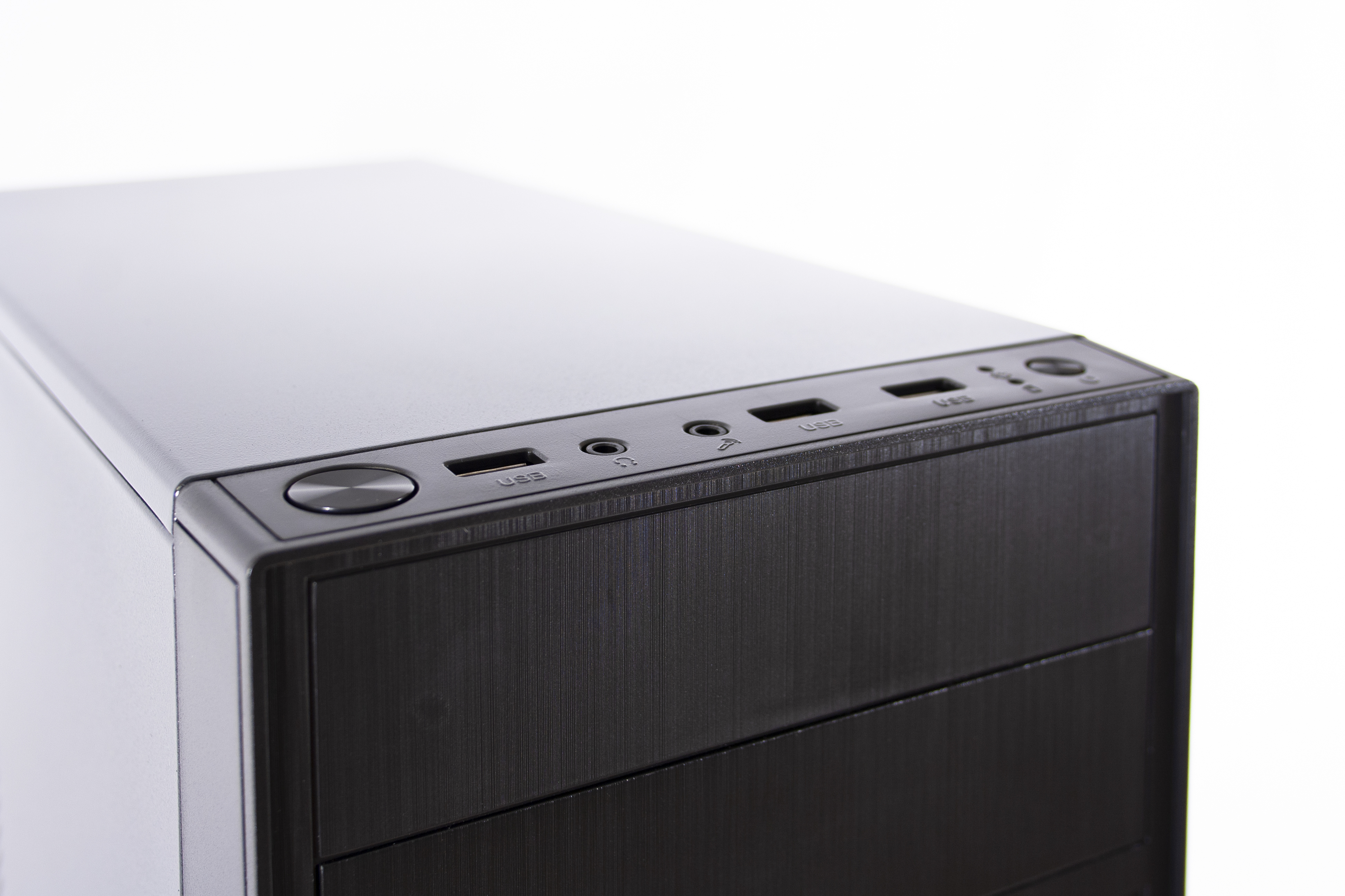 Primo piano della parte superiore di un case per computer nero. Mostra porte USB, jack audio e pulsante di accensione.