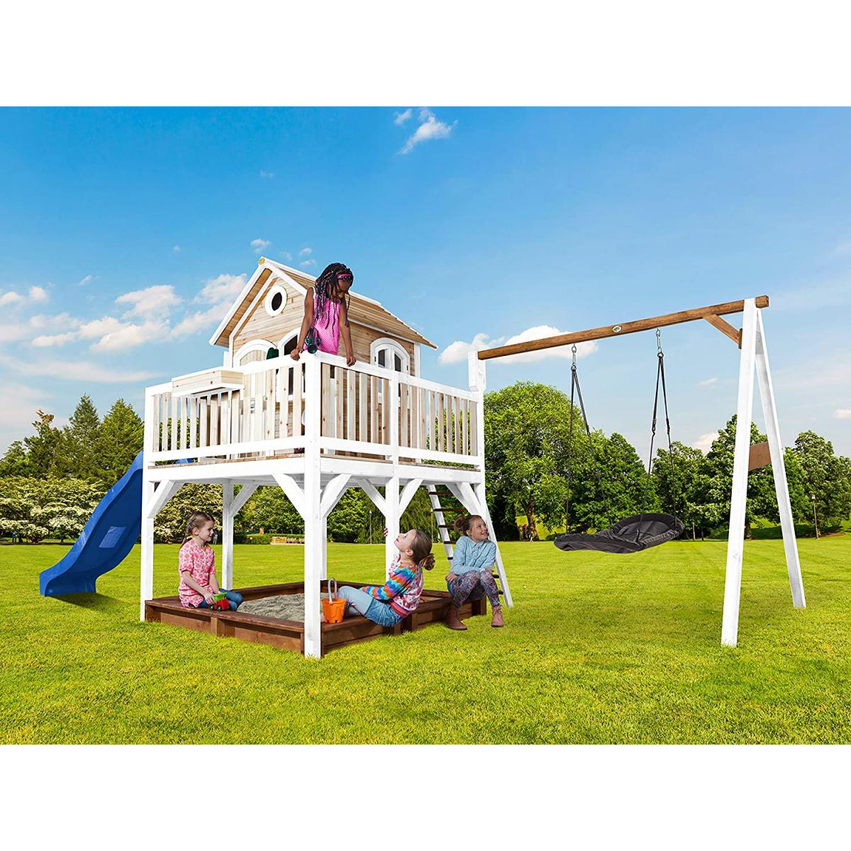 Spielplatzszene mit Kindern. Ein Spielhaus, eine Rutsche und eine Schaukel. Die Kinder spielen, der Himmel ist blau.