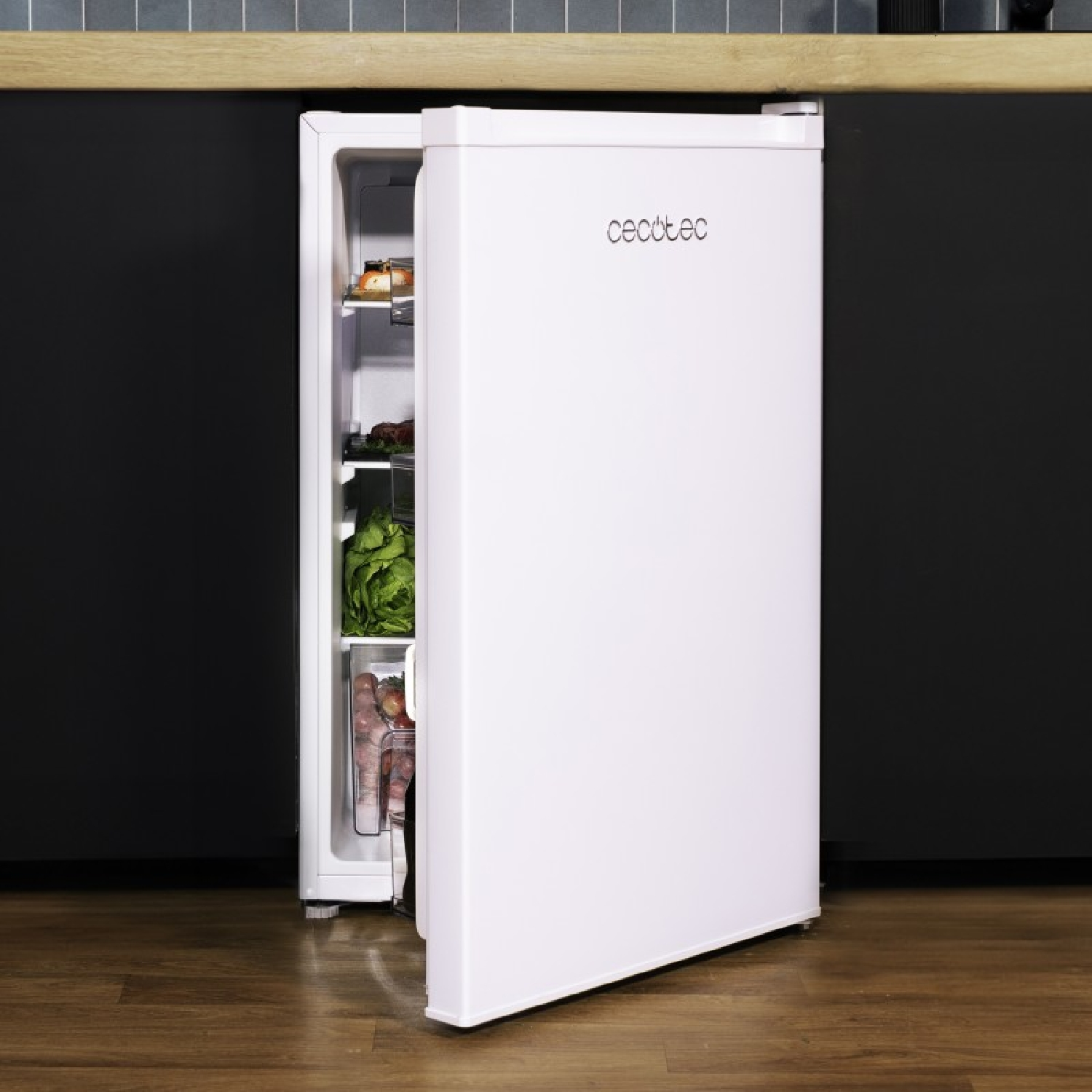 Un mini frigorifero bianco con la porta socchiusa, che rivela ripiani con cibo, su uno sfondo scuro.