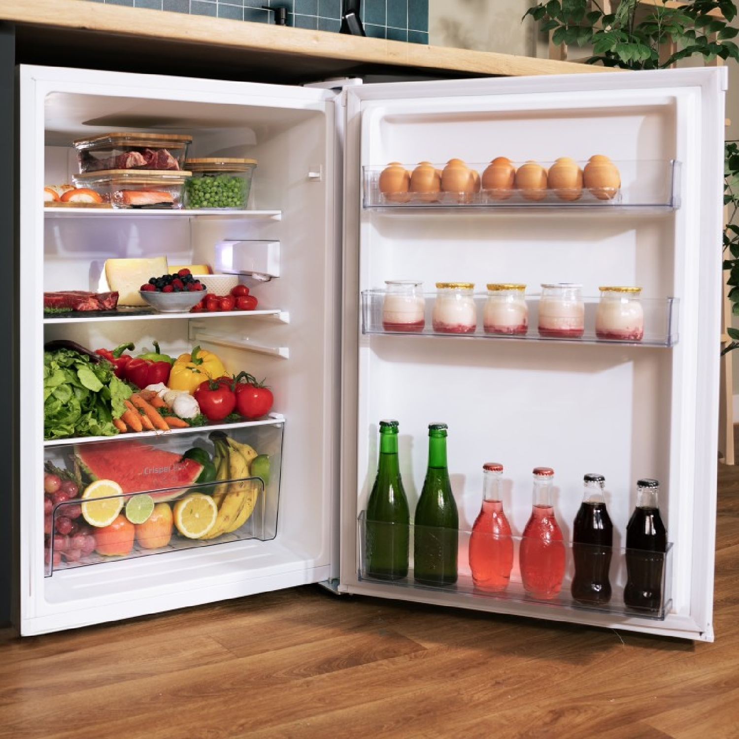 Frigorifero con porta aperta. Frutta, verdura, bevande e uova sono visibili.
