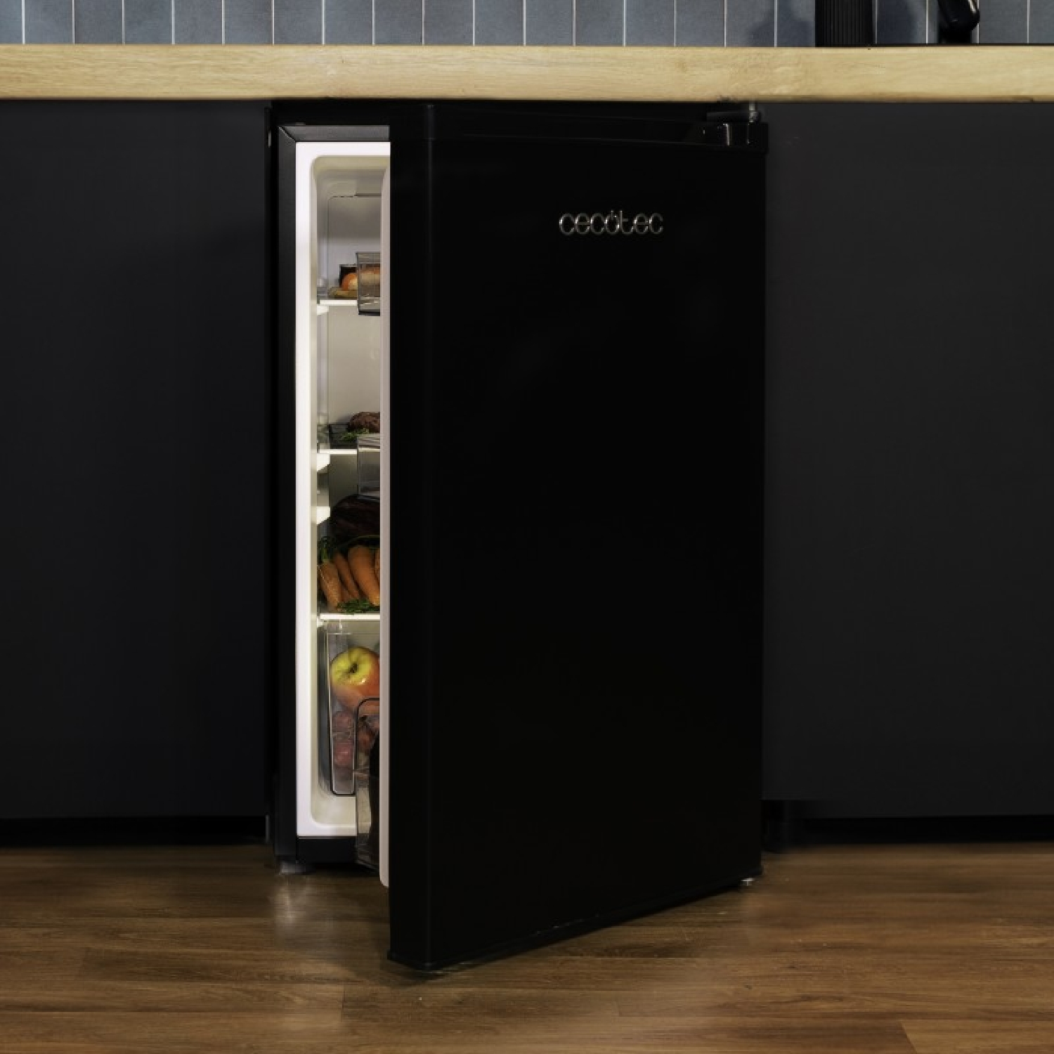 Frigorífico negro. Puerta abierta. Comida dentro. Encimera y pared negras.