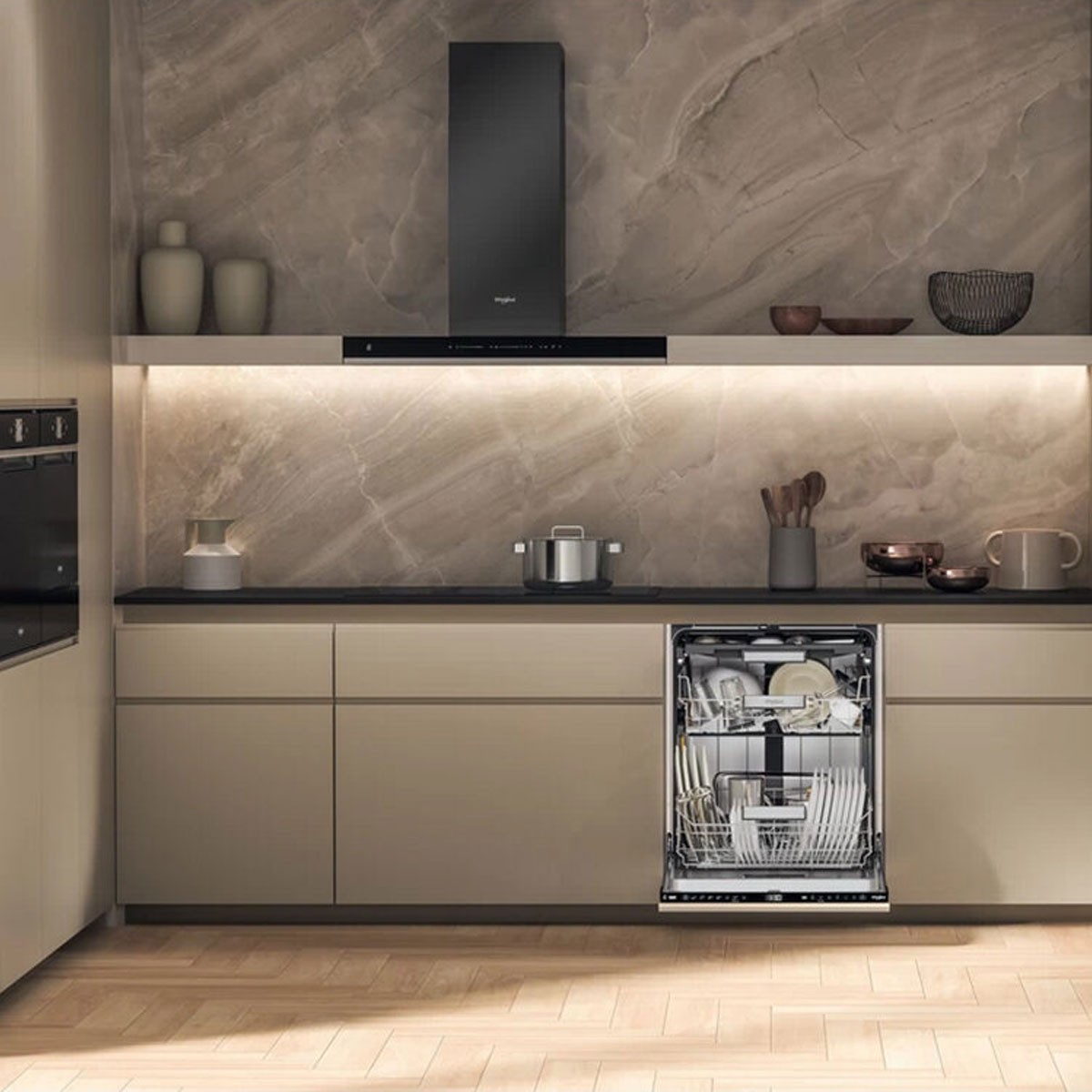 Una cucina moderna con lavastoviglie, mobili scuri, cappa e pavimenti in legno.