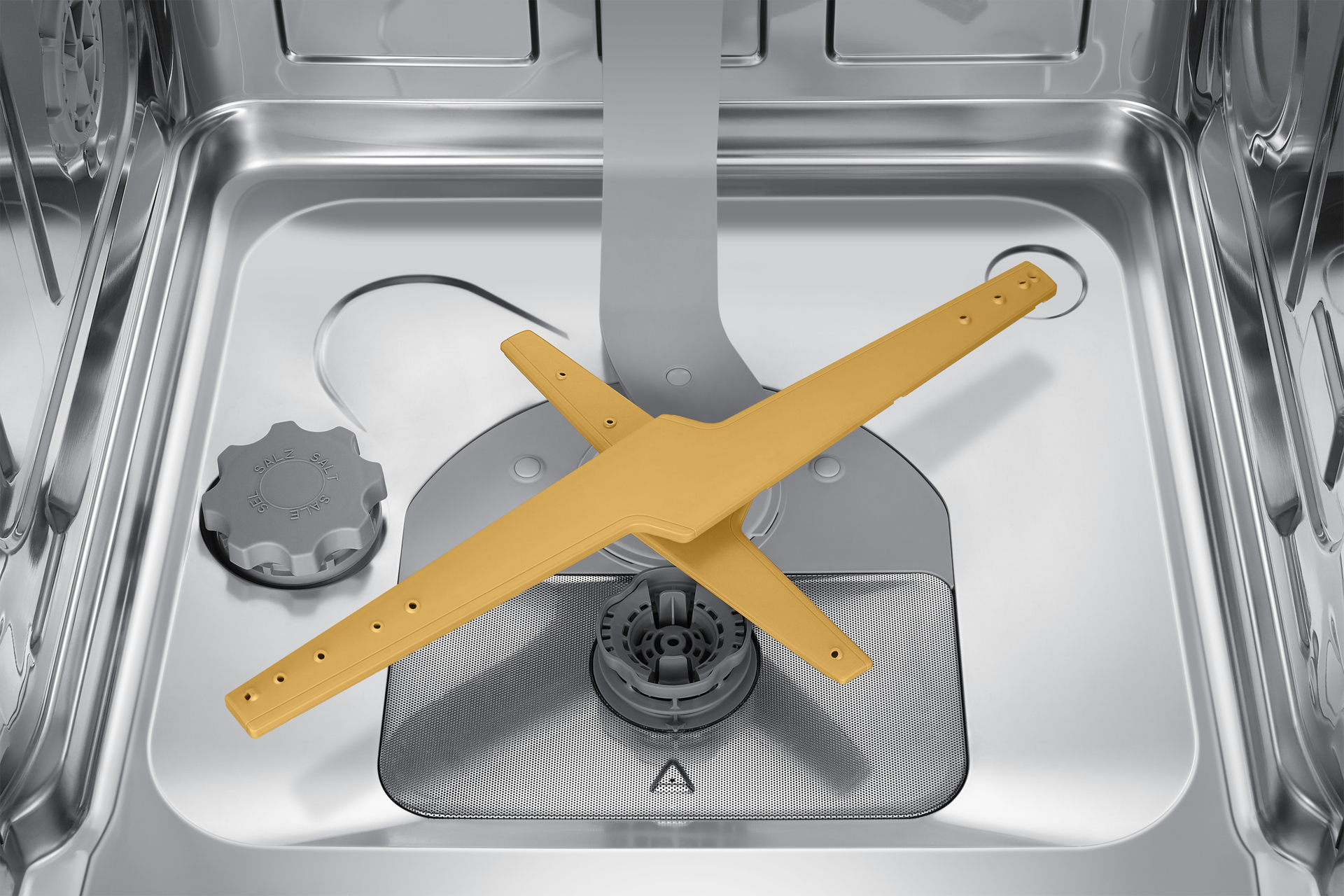 Zbliżenie wnętrza zmywarki. Widoczne żółte ramię natryskowe i szary wlot wody. Stal nierdzewna.