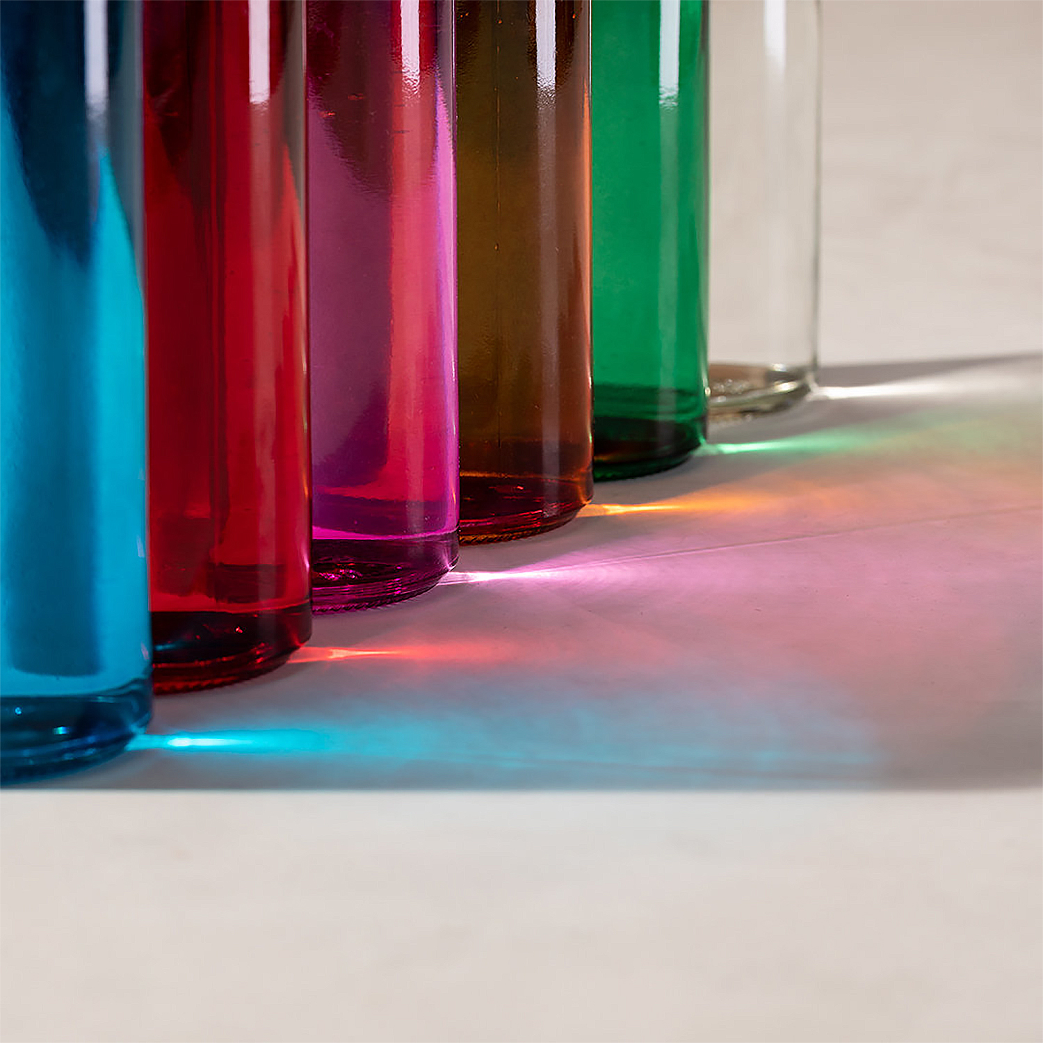 Primer plano de botellas llenas de líquido. Reflejo de luz de arcoíris abajo.