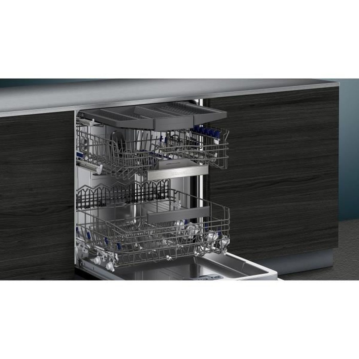 An open dishwasher with three racks, empty. Dark wood paneling in the background.