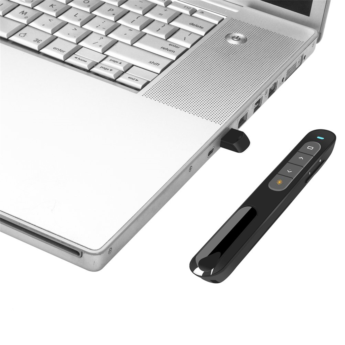 Laptop und eine schwarze Präsentationsfernbedienung. Die Fernbedienung liegt neben dem Laptop, USB-Dongle eingesteckt.