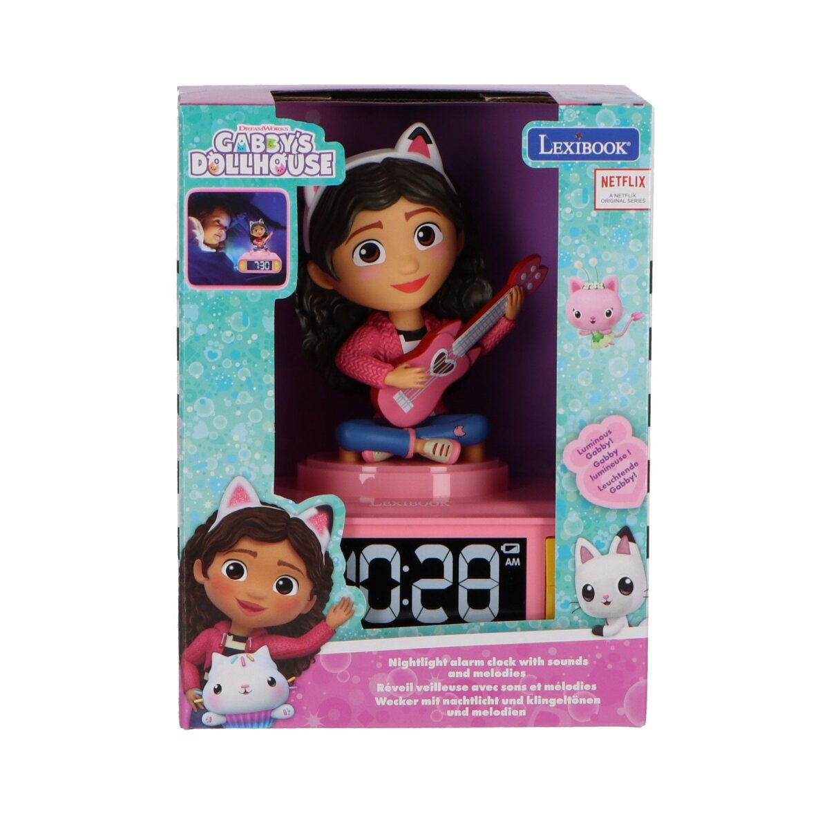 Juguete de despertador de Gabby's Dollhouse en una caja. Una muñeca toca la guitarra. El reloj marca las 10:28 AM.
