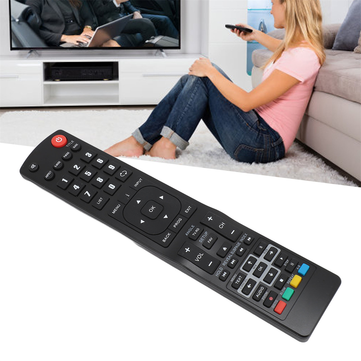 Schwarze TV-Fernbedienung mit vielen Knöpfen. Eine Person hält die Fernbedienung, im Hintergrund ein Fernseher.
