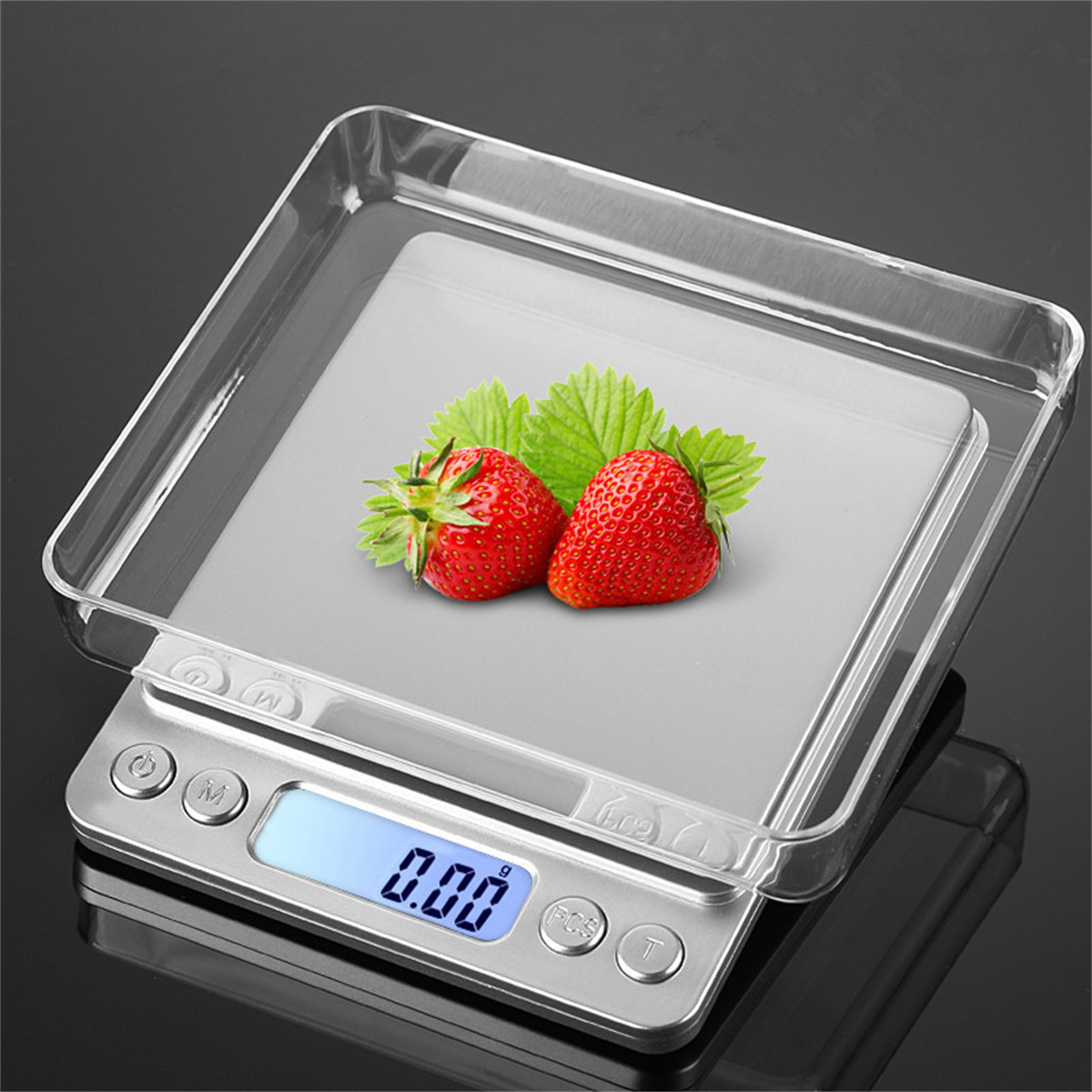 Digitale Küchenwaage mit Erdbeeren auf einer transparenten Ablage.