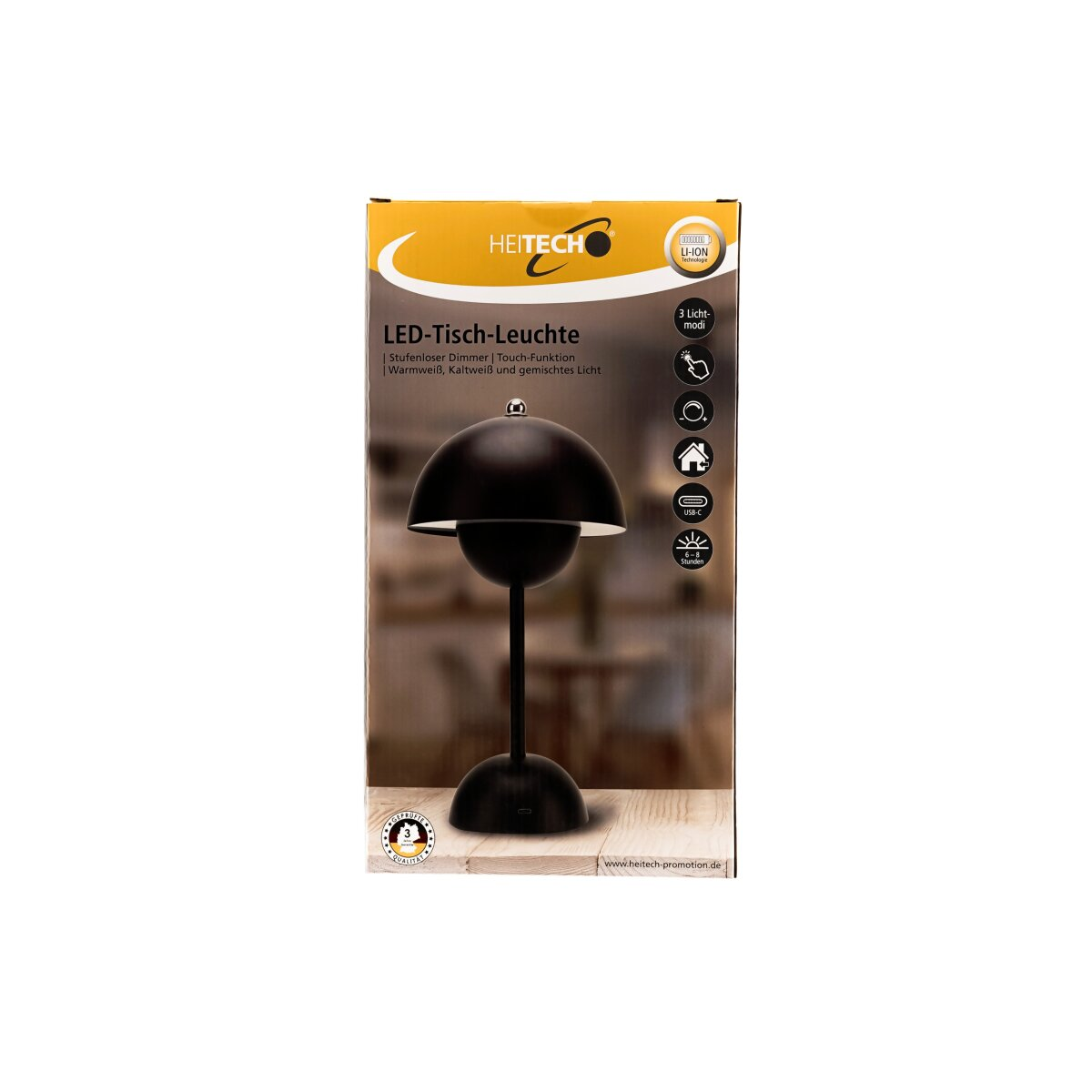 Schwarze Tischleuchte in der Verpackung. Die Verpackung zeigt die Lampe und ihre Funktionen. Der Hintergrund ist unscharf.