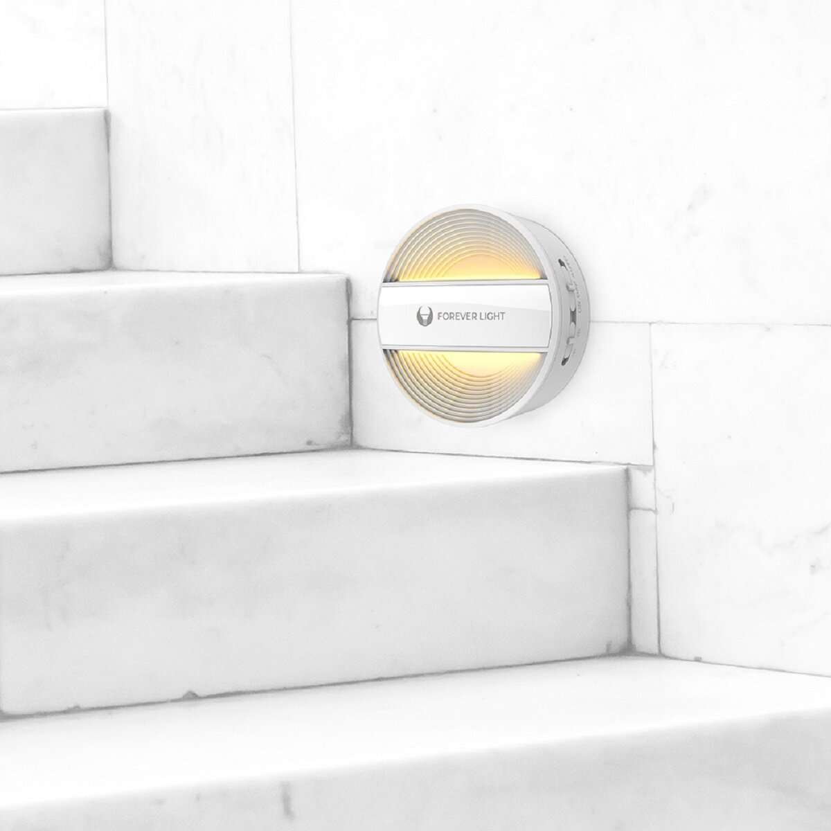 Eine weiße Wandleuchte mit silbernem Rand, montiert auf einer weißen Marmortreppe. Das Licht hat das Forever Light Logo.