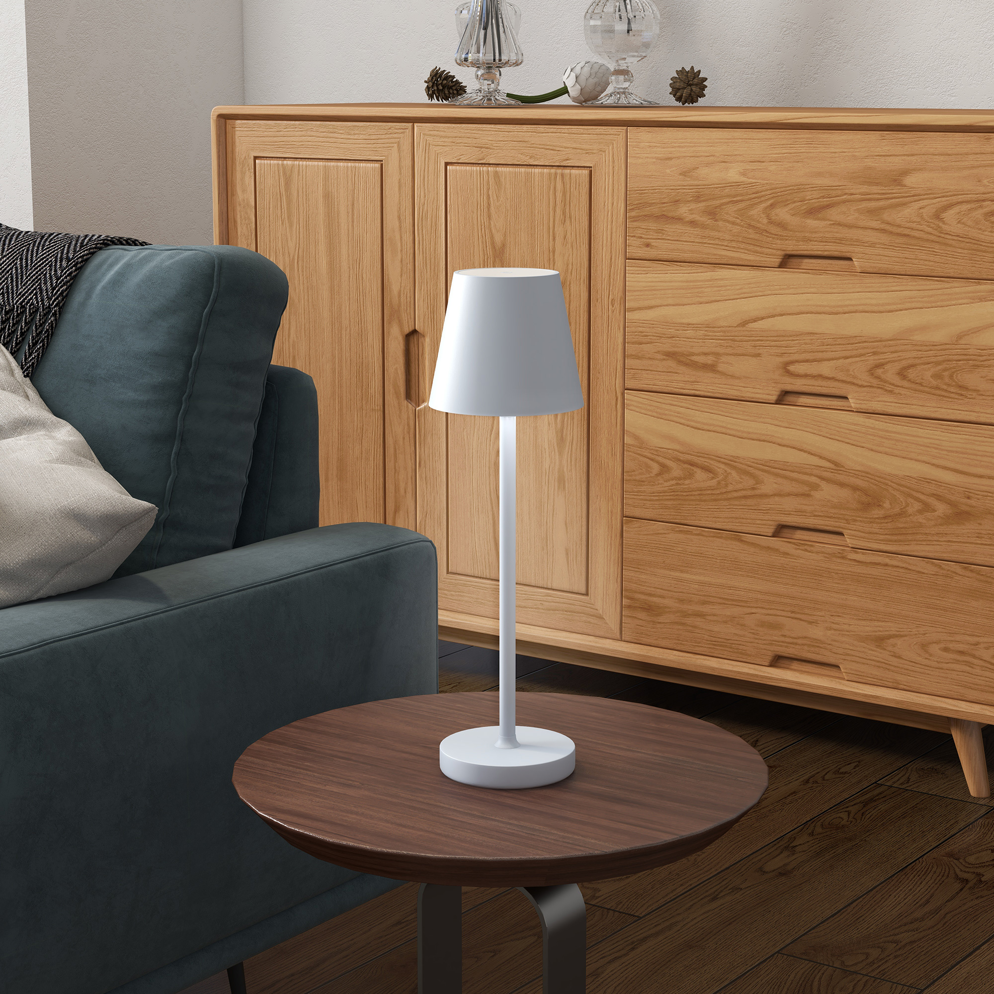 Lámpara blanca sobre mesa de madera. Sofá turquesa y armario de madera detrás.