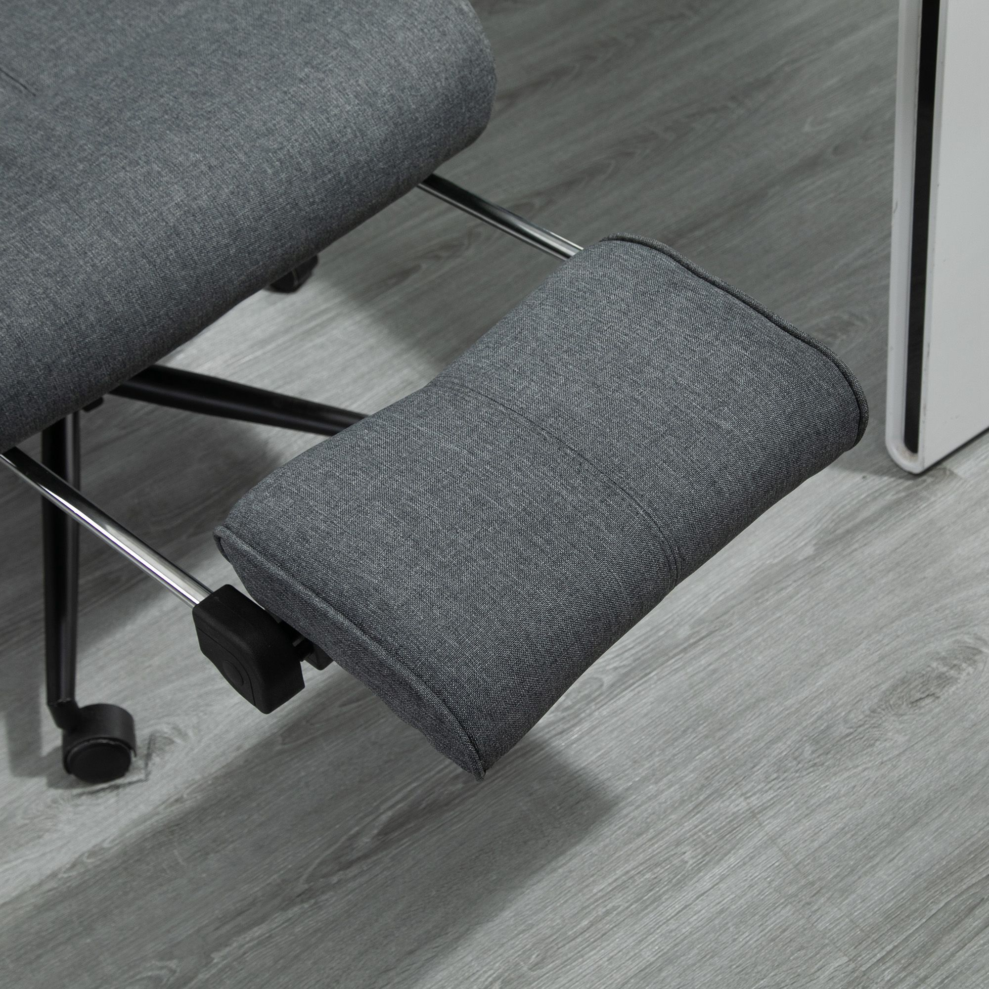 Una sedia inginocchiata grigia con un poggiaginocchia grigio, su un pavimento in legno grigio chiaro.