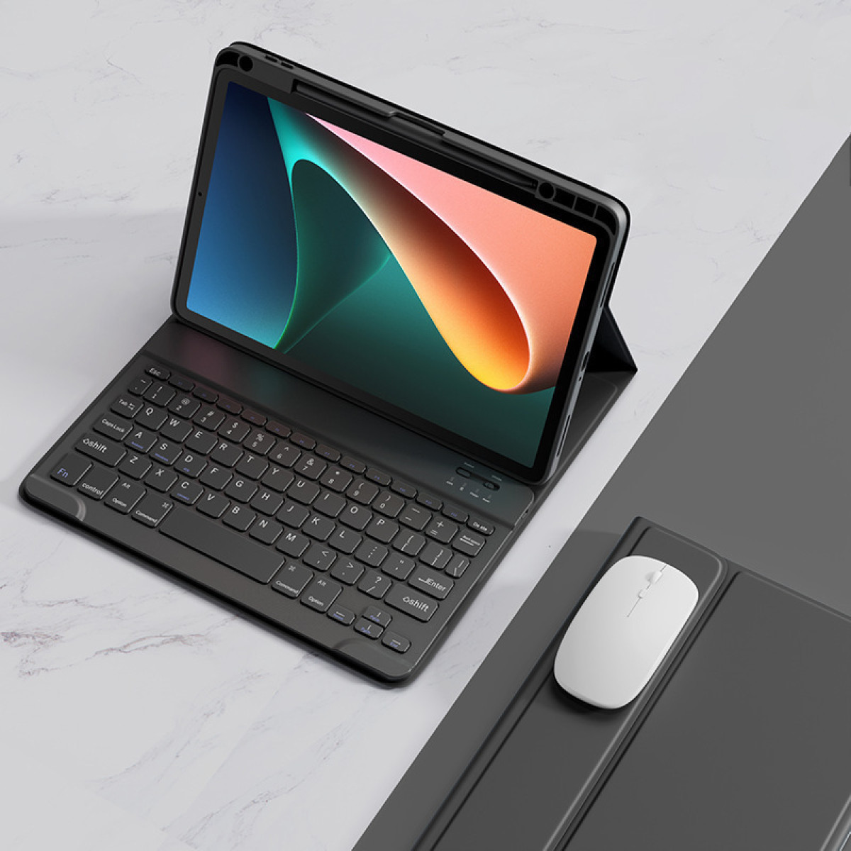 Schwarzes Tablet mit Tastatur und weißer Maus auf grauer Oberfläche. Der Bildschirm zeigt ein farbenfrohes Bild.