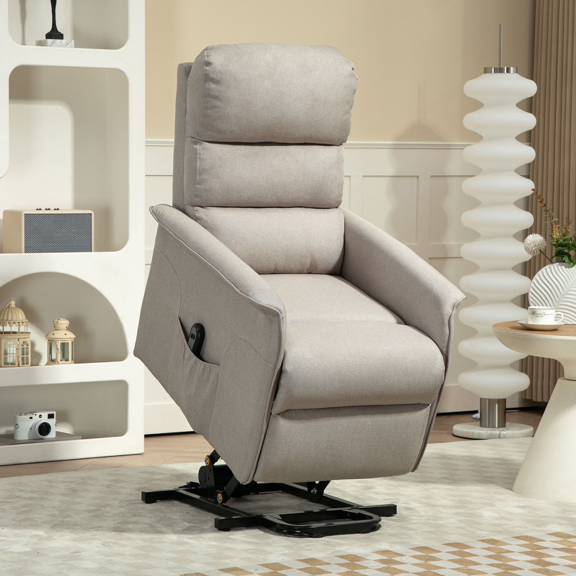 Sillón reclinable beige en una habitación con estantería blanca y lámpara.