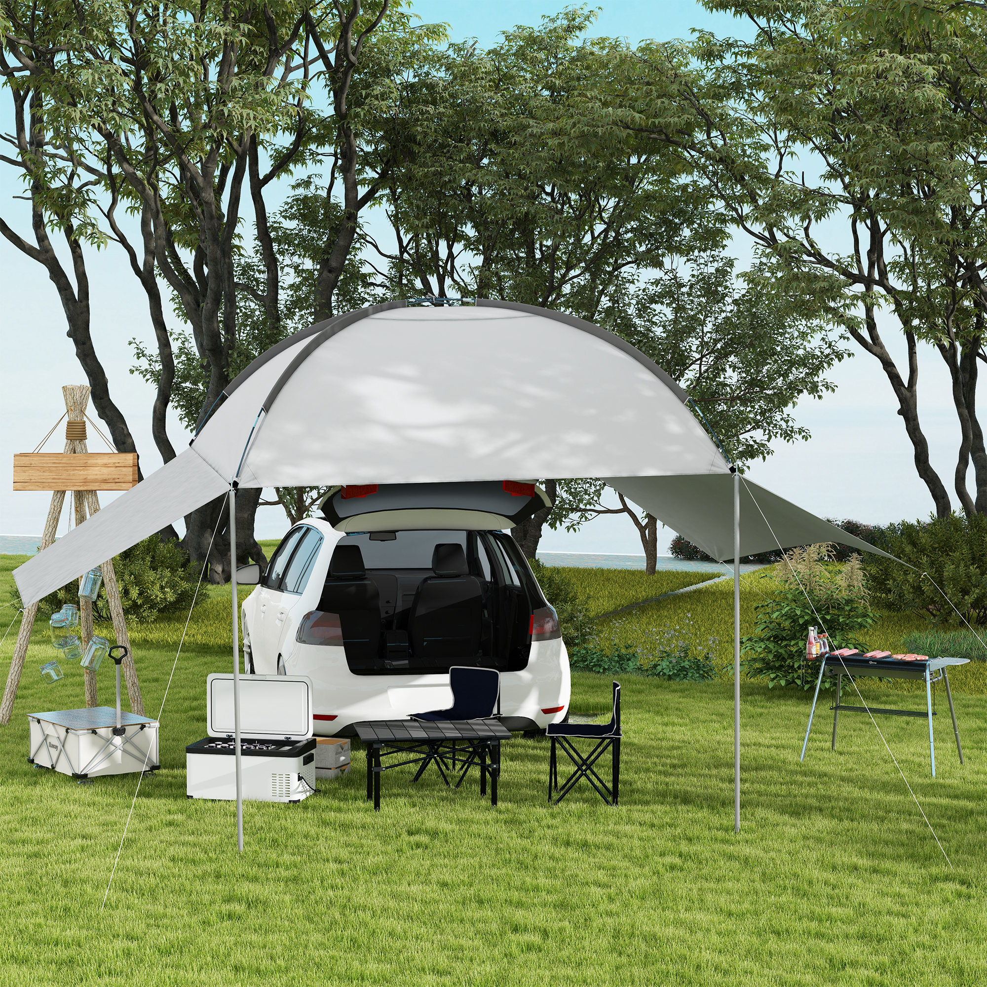 Un'auto con un allestimento da campeggio, tra cui una tenda, un tavolo, sedie e una borsa frigo, sull'erba.