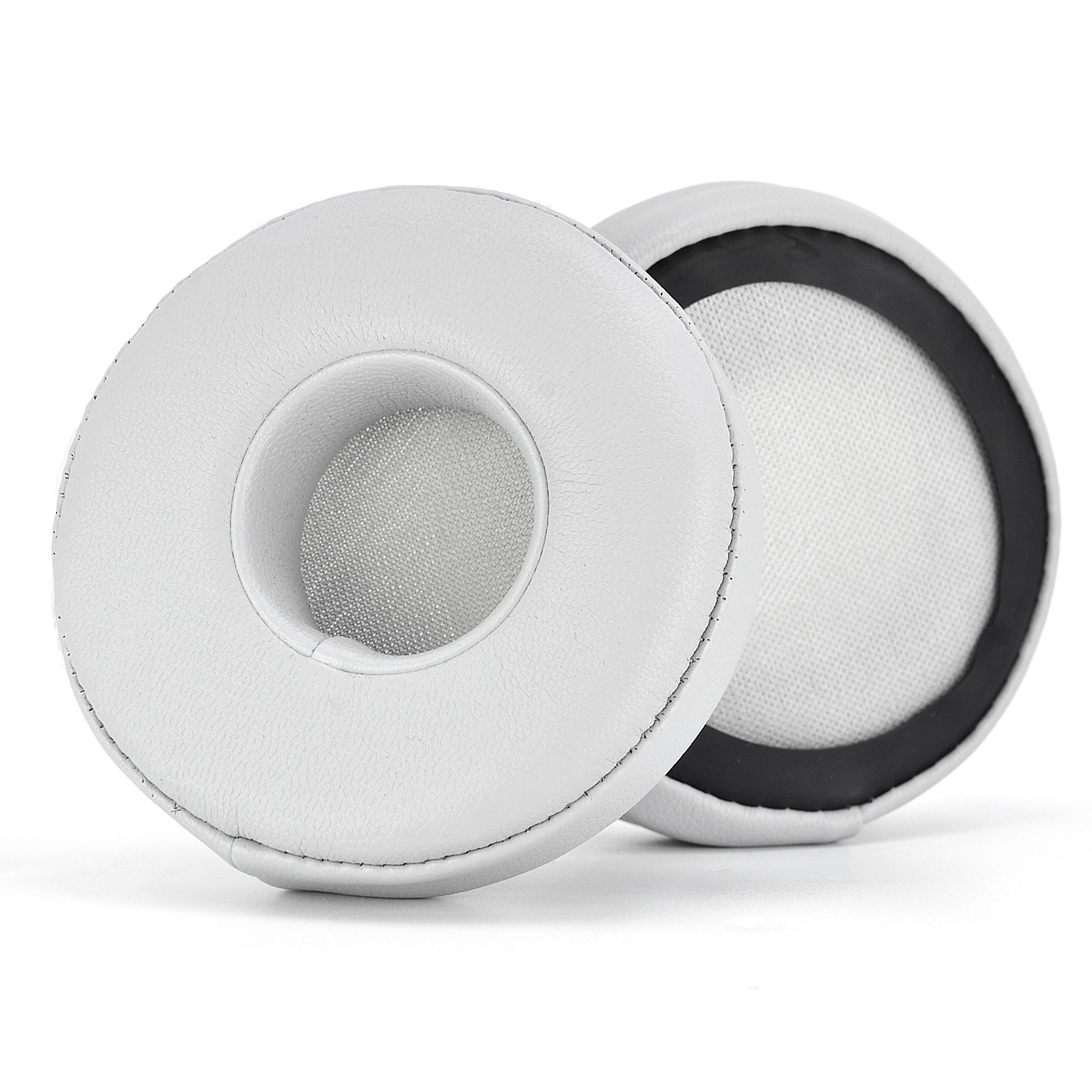 Due cuscinetti auricolari bianchi per cuffie, finiture nere, sfondo bianco.