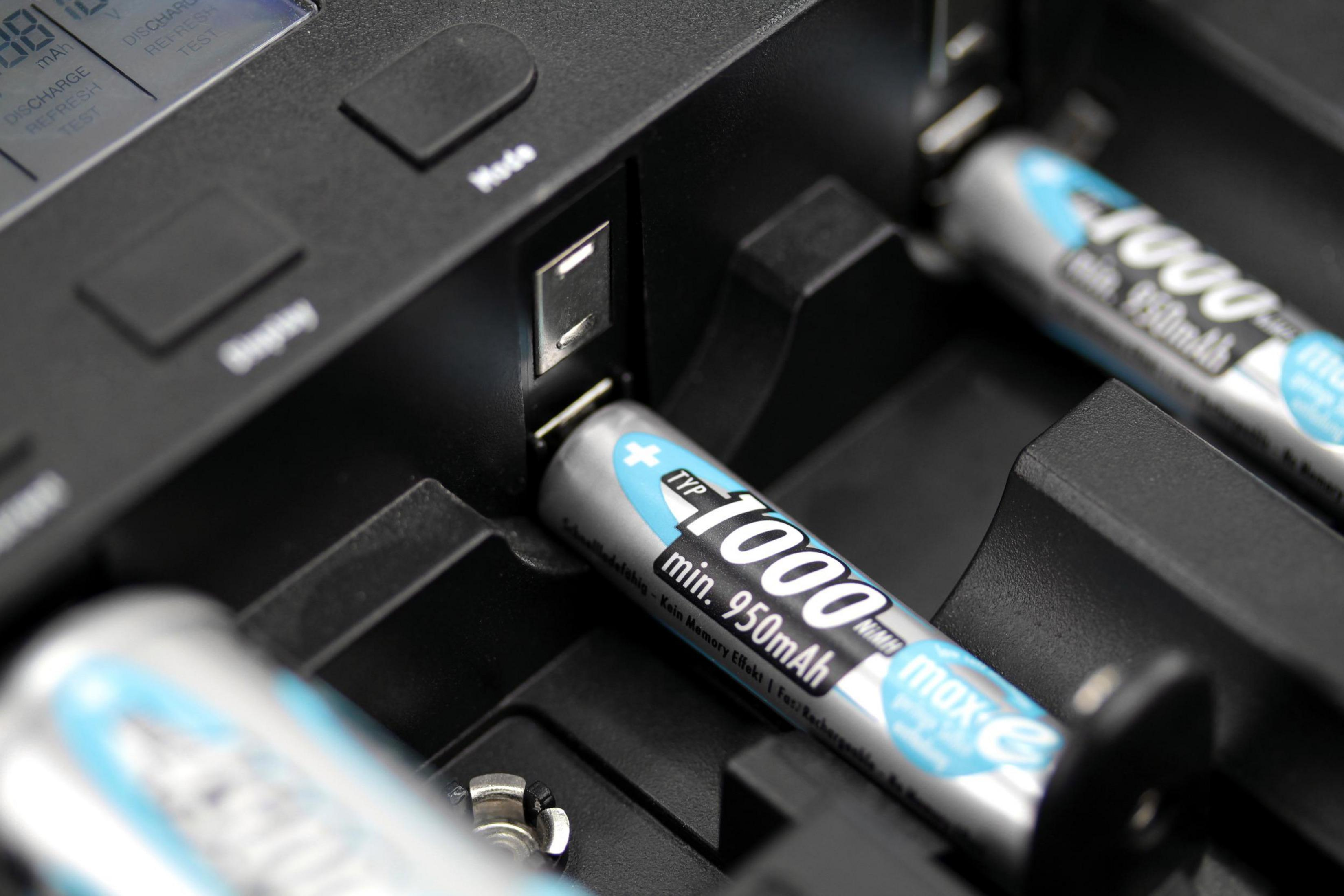 Batterijen die worden opgeladen in een zwarte oplader.