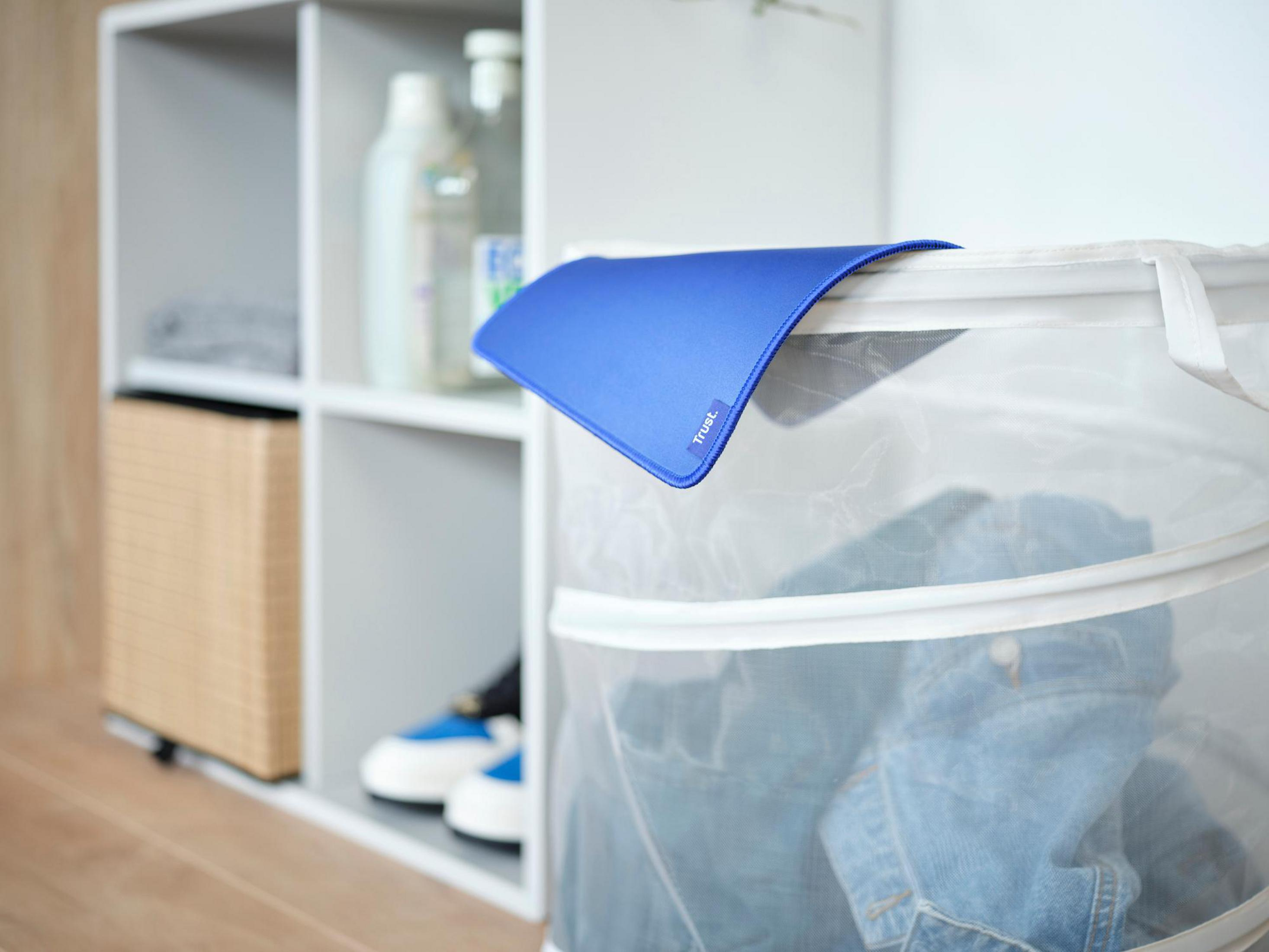 Niebieska podkładka pod mysz nad koszem na pranie. Pranie, półka z przedmiotami.