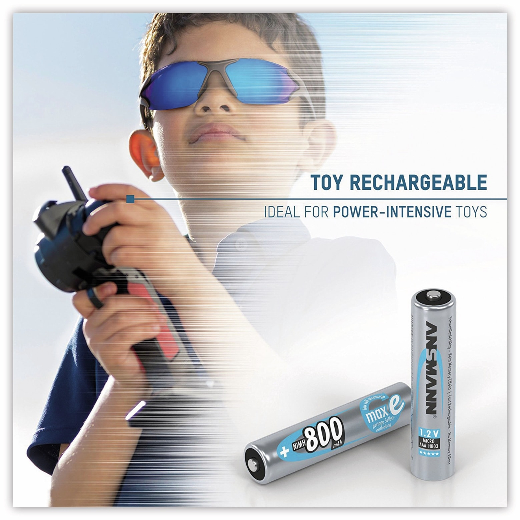 Ein Junge mit Sonnenbrille, der eine Spielzeugfernbedienung hält. Batterien und Text sind zu sehen.