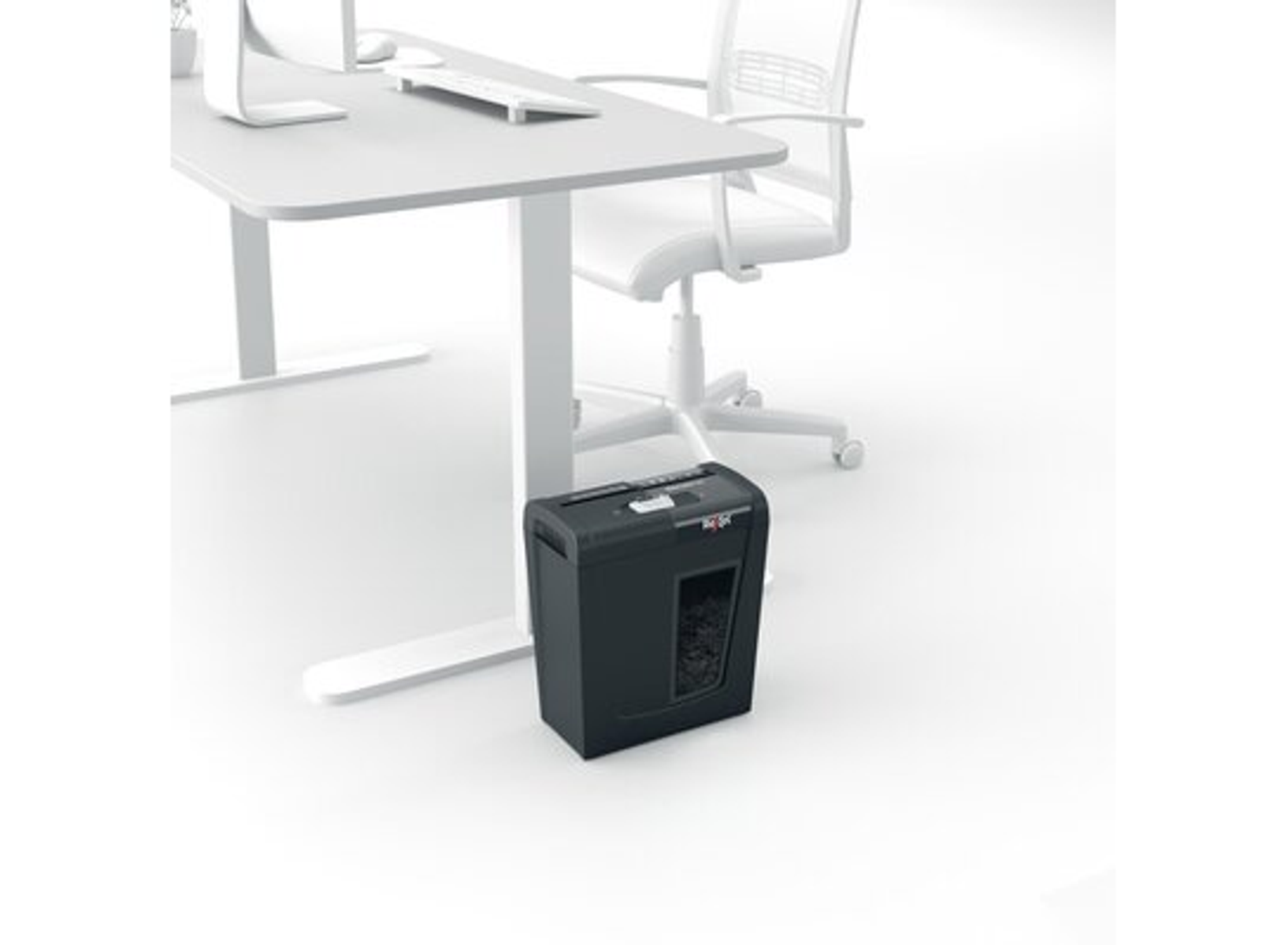 Czarna niszczarka pod białym biurkiem i krzesłem.