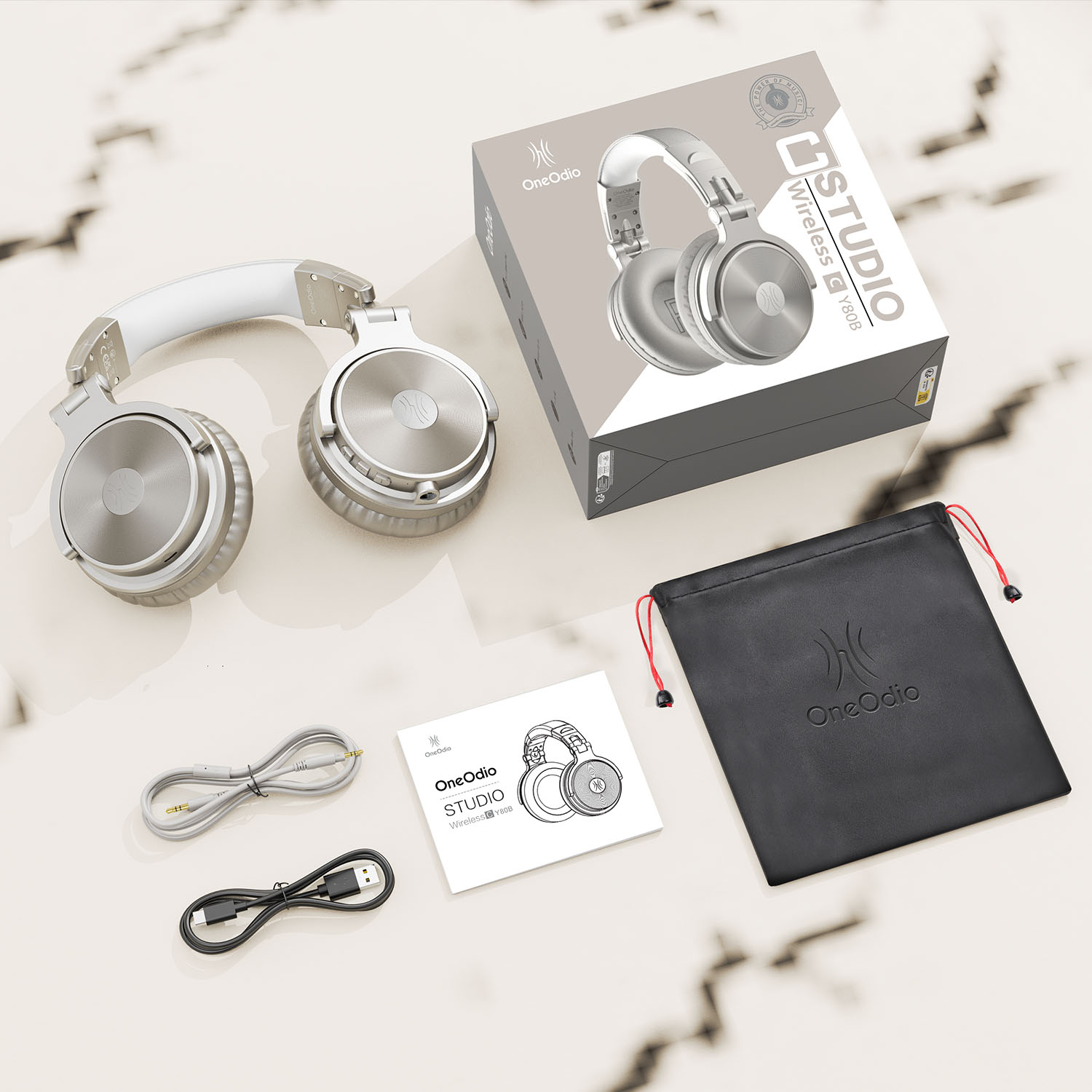 Studio hoofdtelefoon, doos, kabels en accessoires op een marmeren oppervlak.