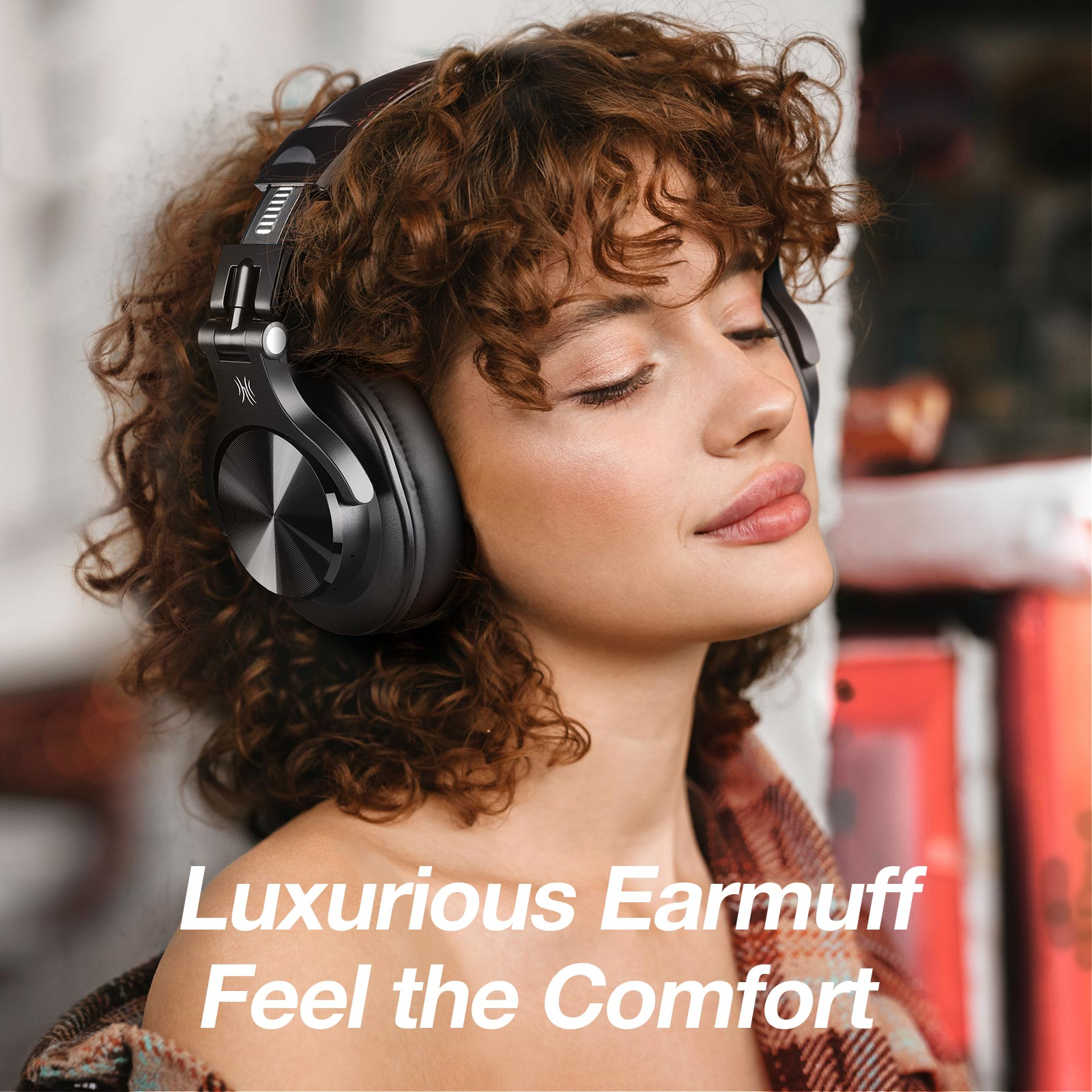 Vrouw met zwarte hoofdtelefoon. Krullend haar, gesloten ogen, neutrale uitdrukking. Tekst: Luxe oorkap, Voel het comfort.