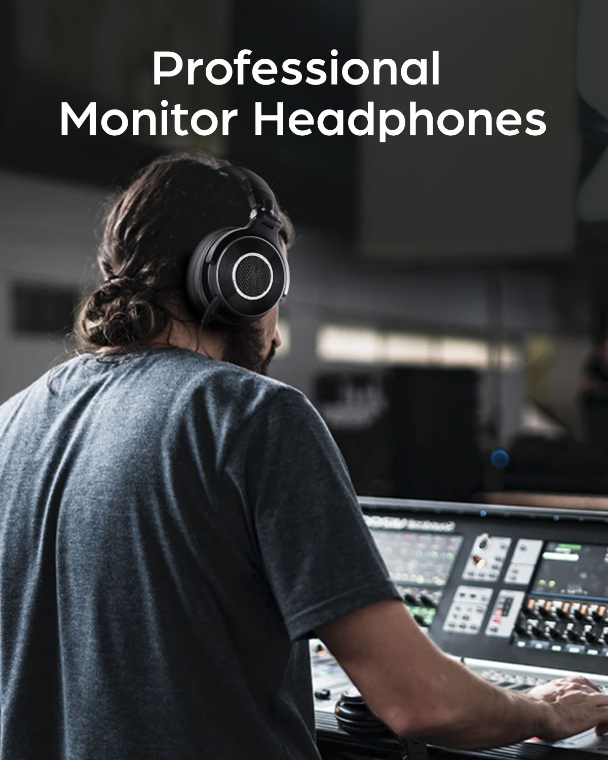 A man wearing black headphones, facing a sound mixing board in a studio setting. The background is dark.