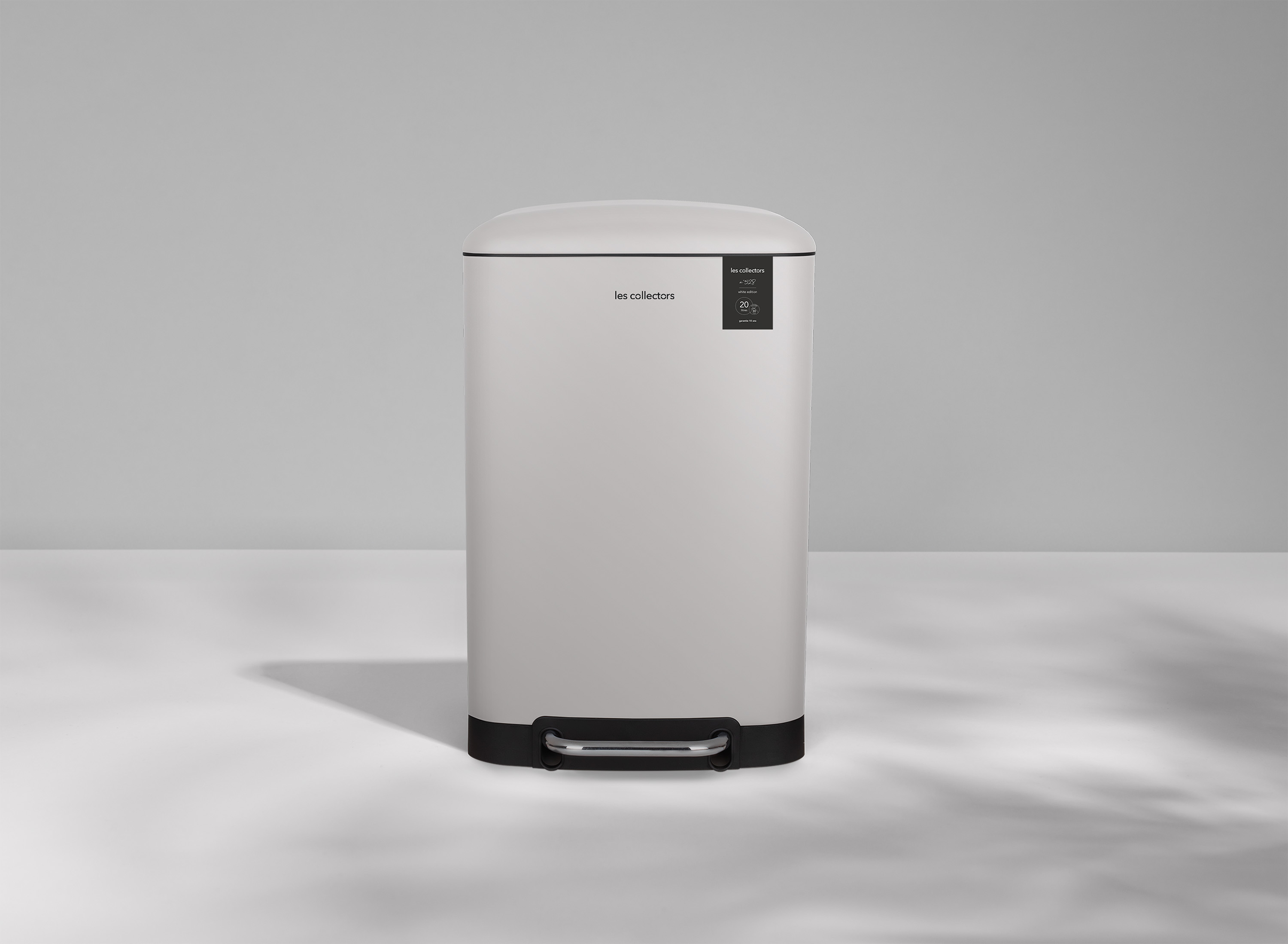 Ein weißer, rechteckiger Mülleimer mit schwarzer Basis und Fußpedal.