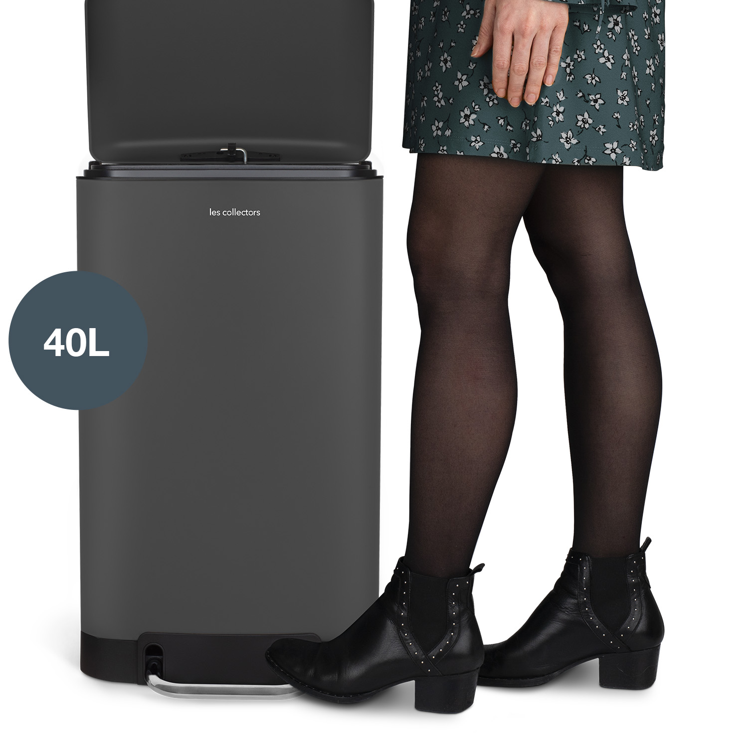 Ein grauer 40L-Mülleimer mit Deckel, neben einer Person in einem geblümten Rock und schwarzen Stiefeln.