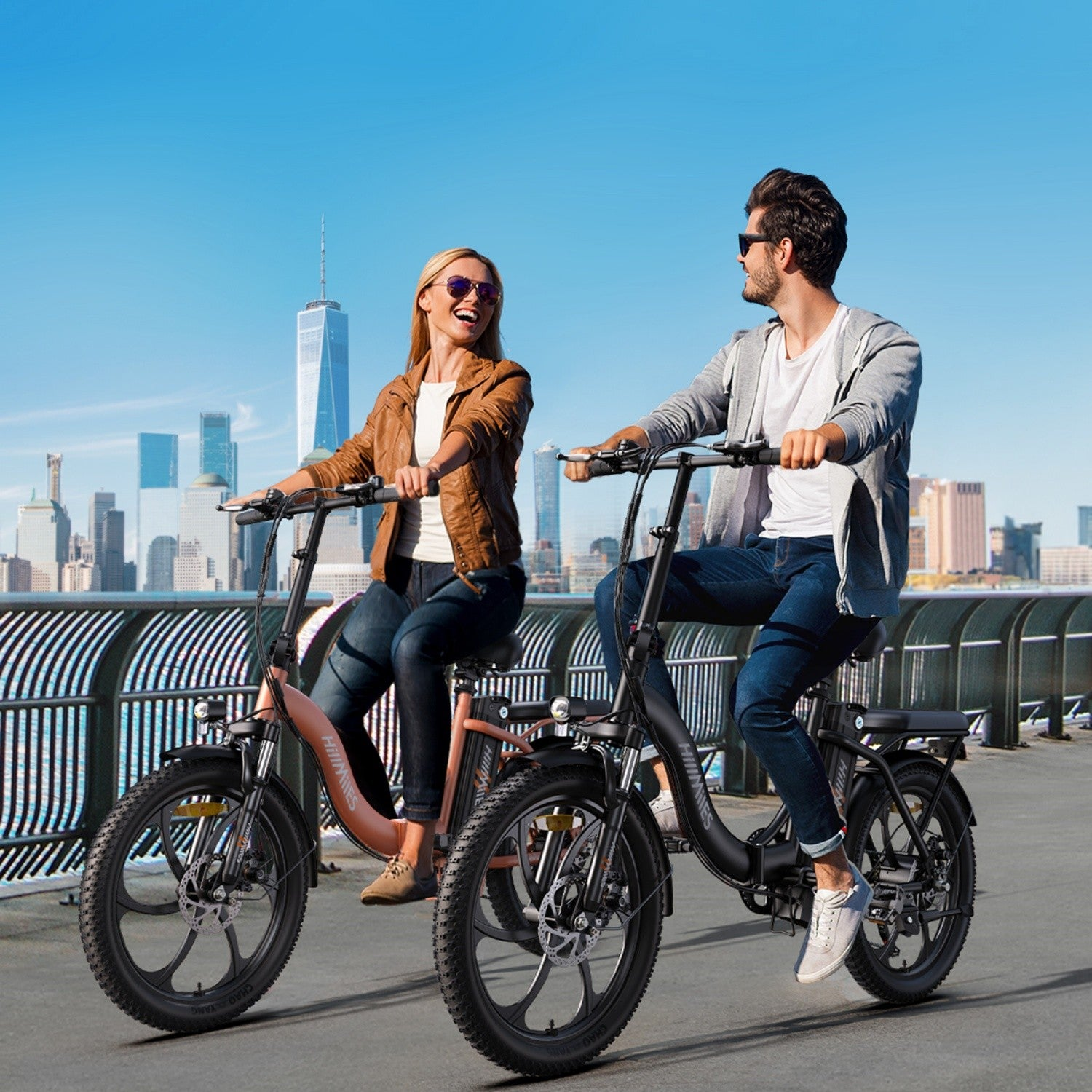Due persone in bici elettriche verso la città, giornata di sole.