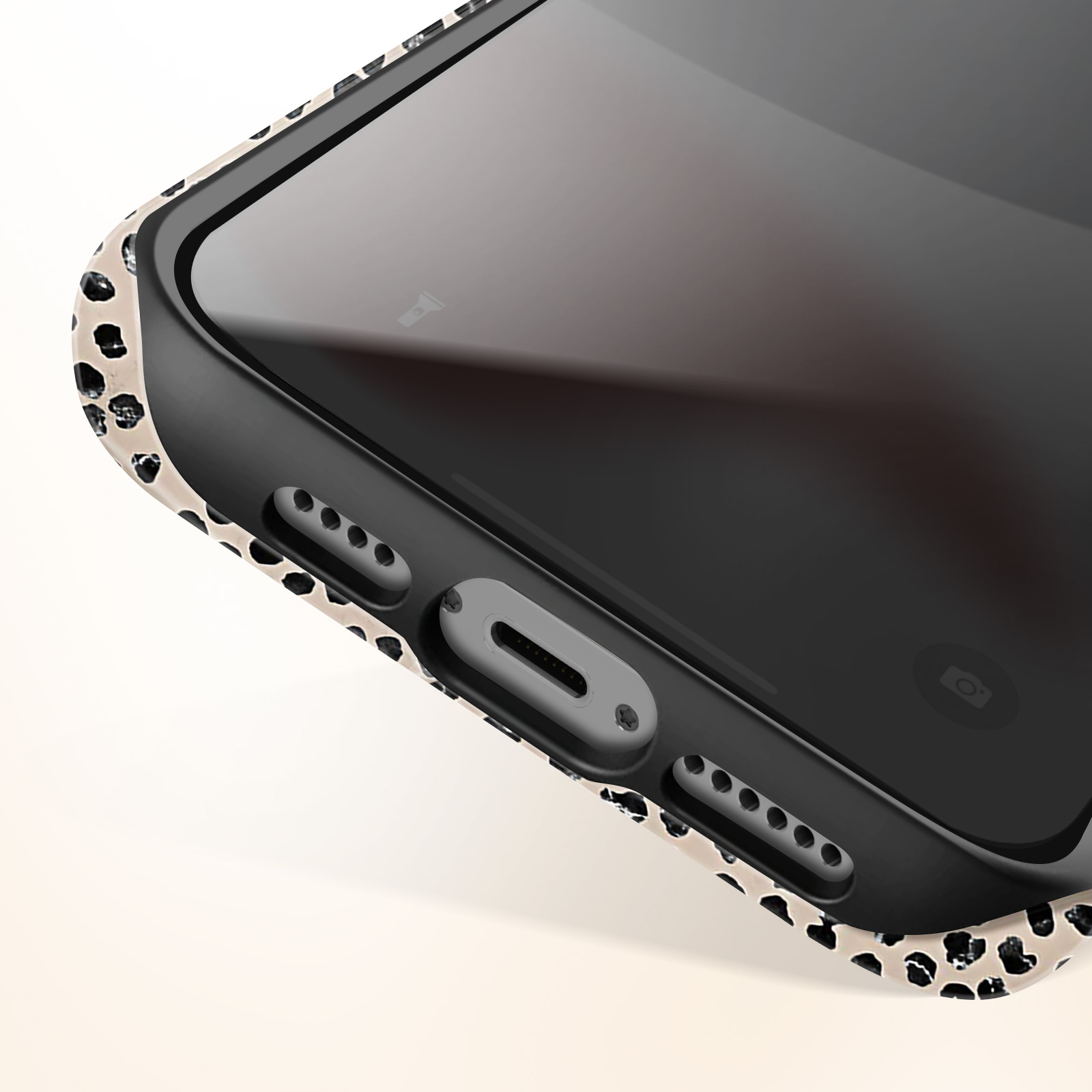Primo piano di un telefono con custodia nera. La custodia ha un design maculato.