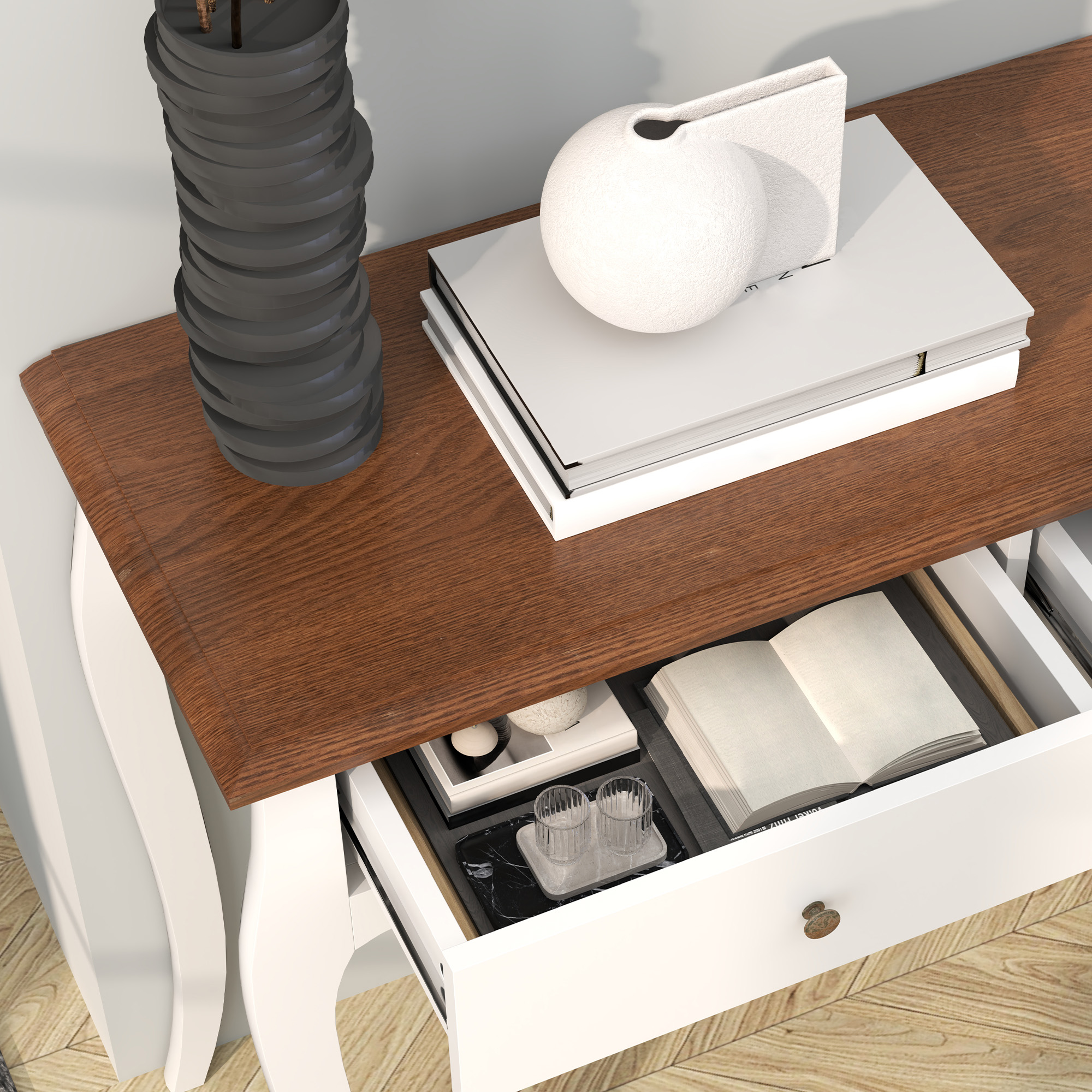 Primo piano di una consolle con oggetti sopra: vaso, libri e un cassetto aperto con oggetti all'interno.