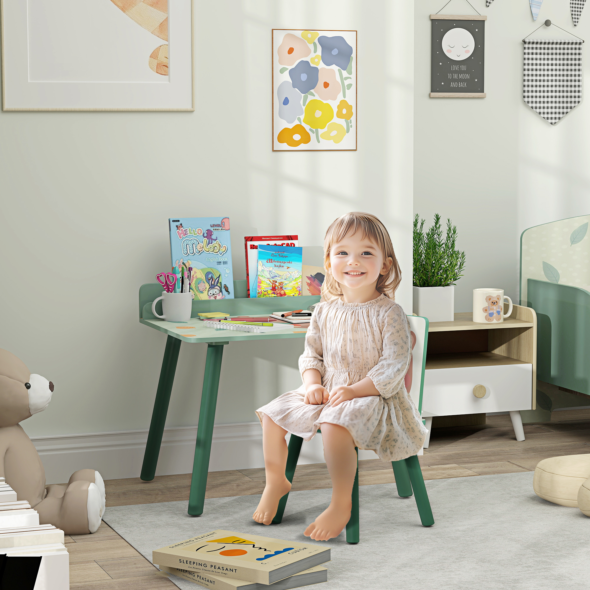 Bambina sorridente seduta a una scrivania verde con libri e materiale artistico.