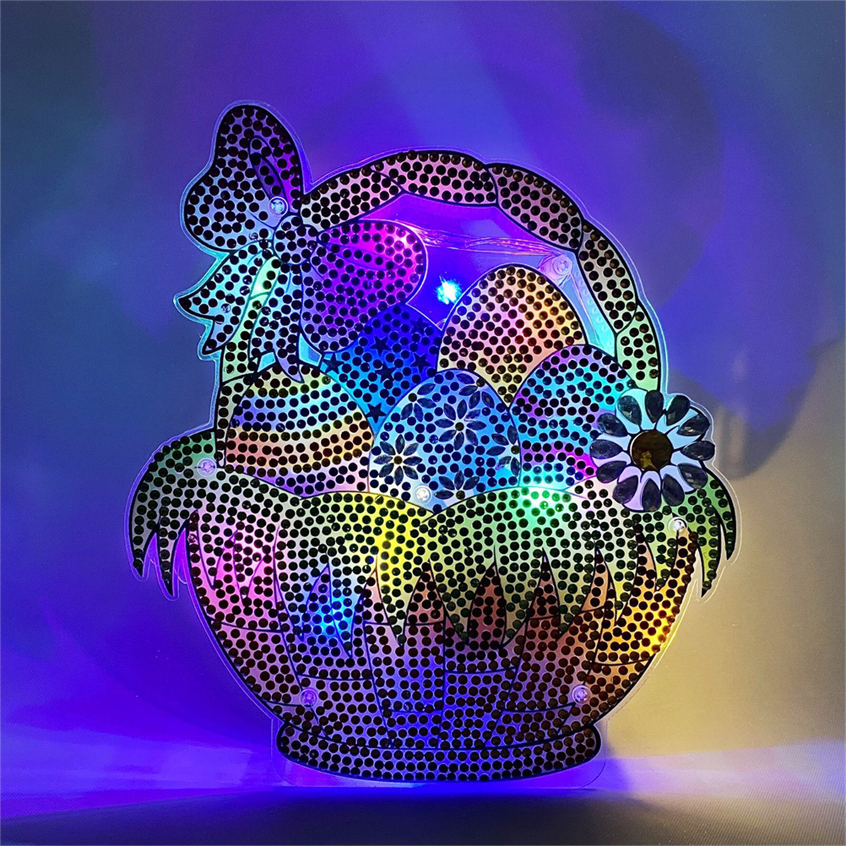 Osterkorb-Dekoration mit mehreren bunten Eiern. Der Korb leuchtet mit hellen, bunten Lichtern.