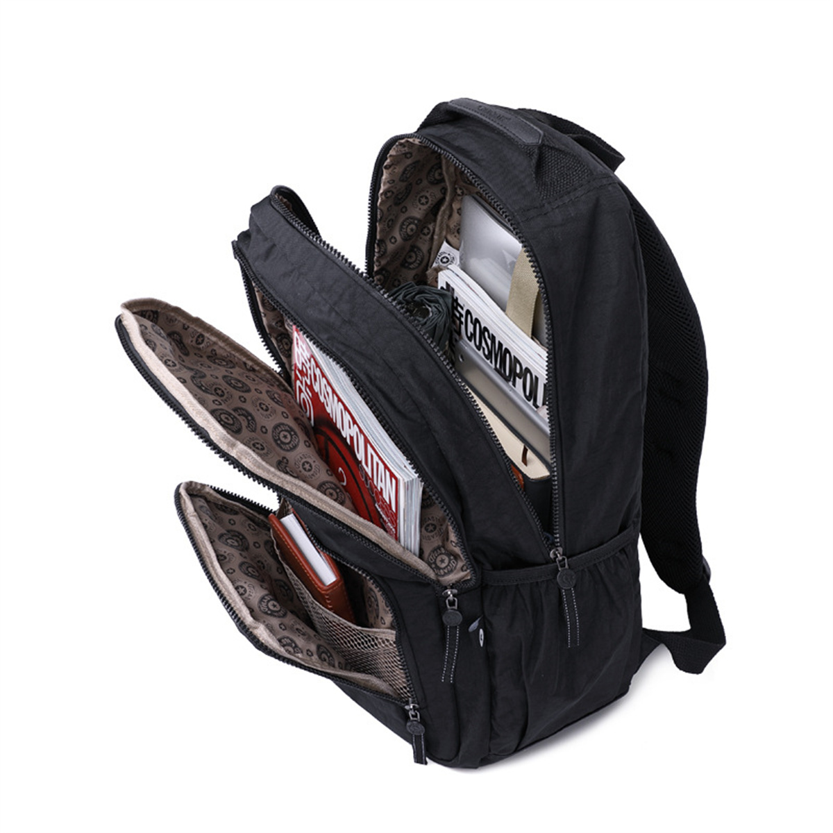 Ein schwarzer Rucksack mit mehreren Taschen, gefüllt mit Gegenständen. Offen, zeigt Inhalt: Zeitschriften, Brieftasche.
