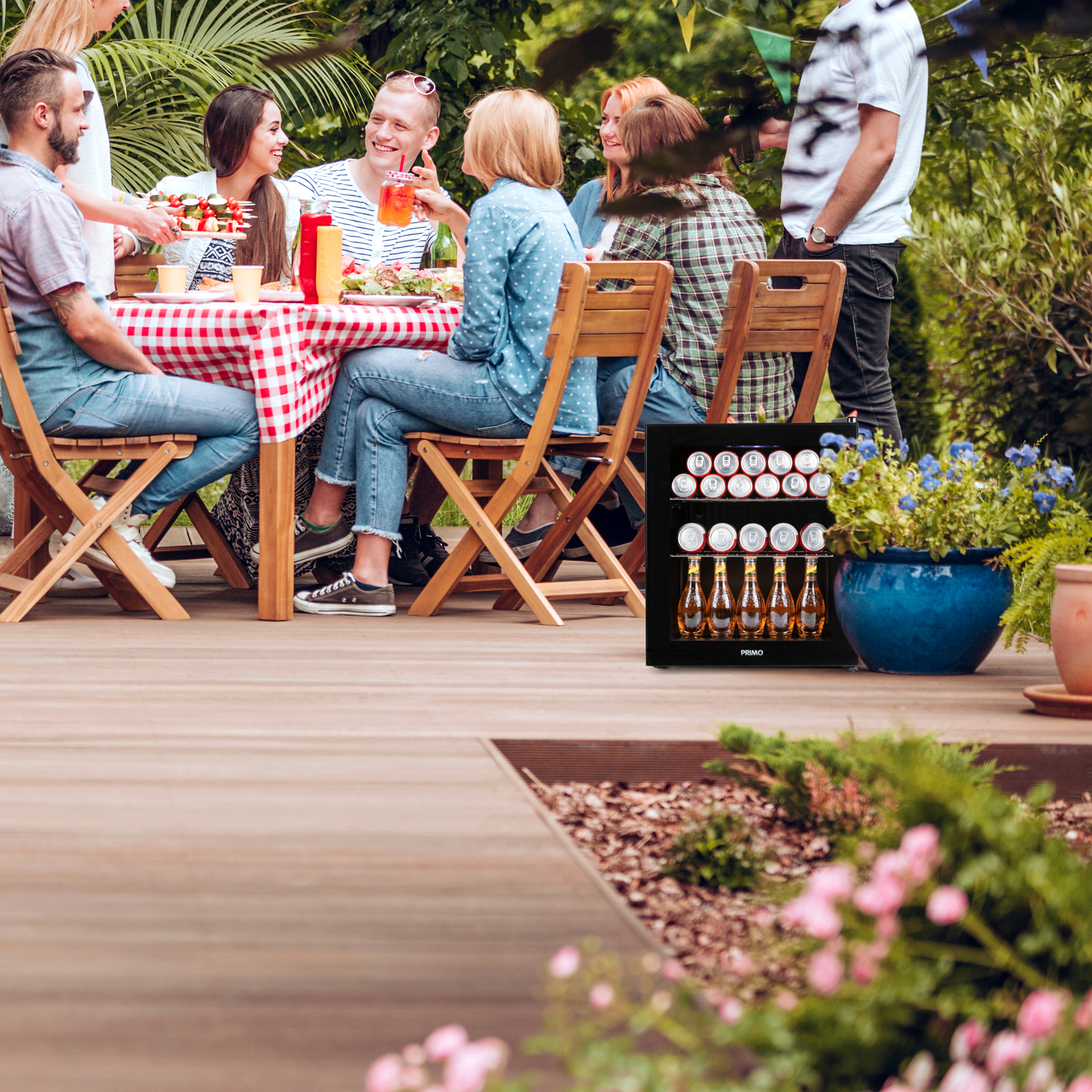 Groep mensen aan een tafel, met een koeler met drankjes op de achtergrond.