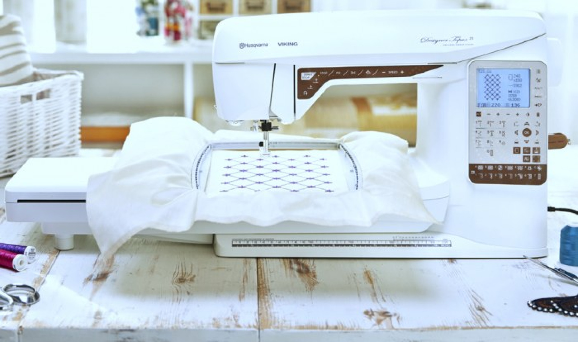 Máquina de coser sobre mesa de madera. Fondo blanco.