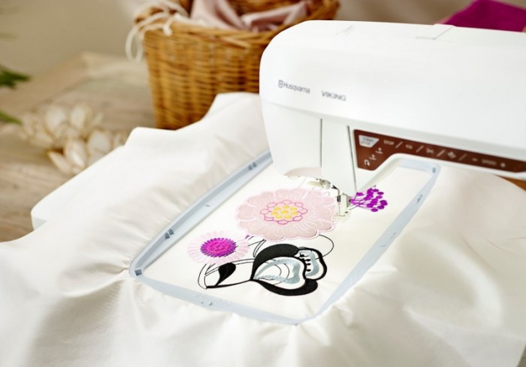 Máquina de coser bordando un diseño floral en tela blanca.