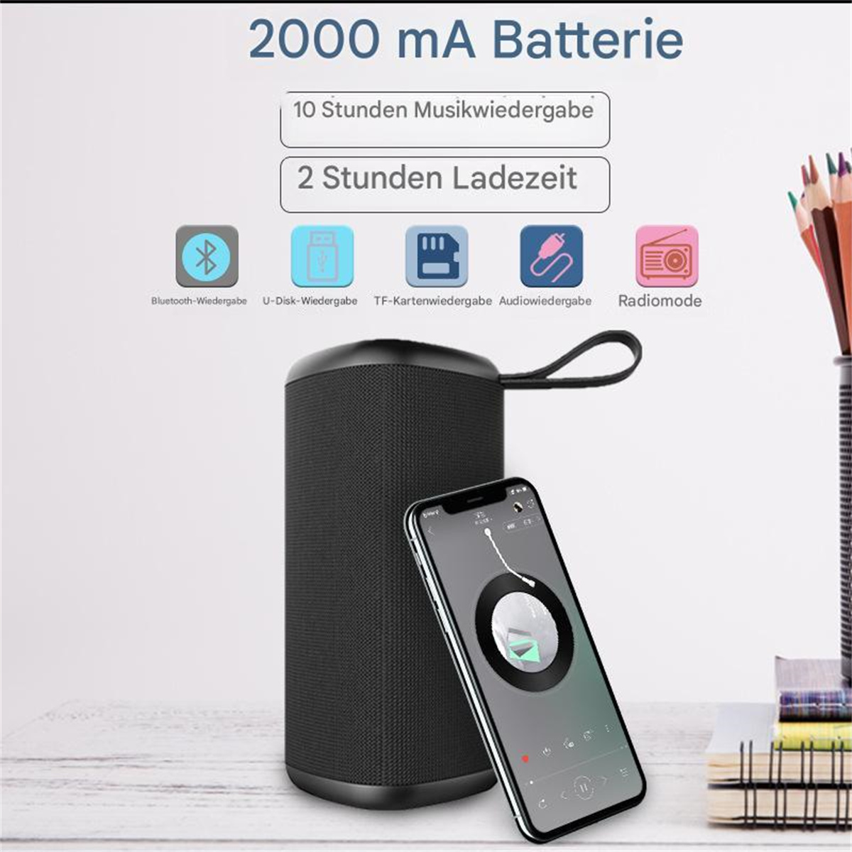 Schwarzer Lautsprecher mit Musik-App auf dem Telefon. Text zeigt Batterie- und Wiedergabezeiten.
