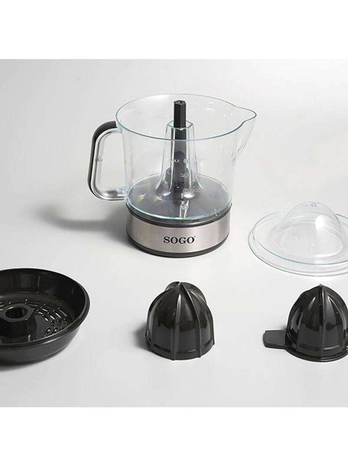 Electrodoméstico de cocina desmontado con recipiente transparente, base negra y varios accesorios.